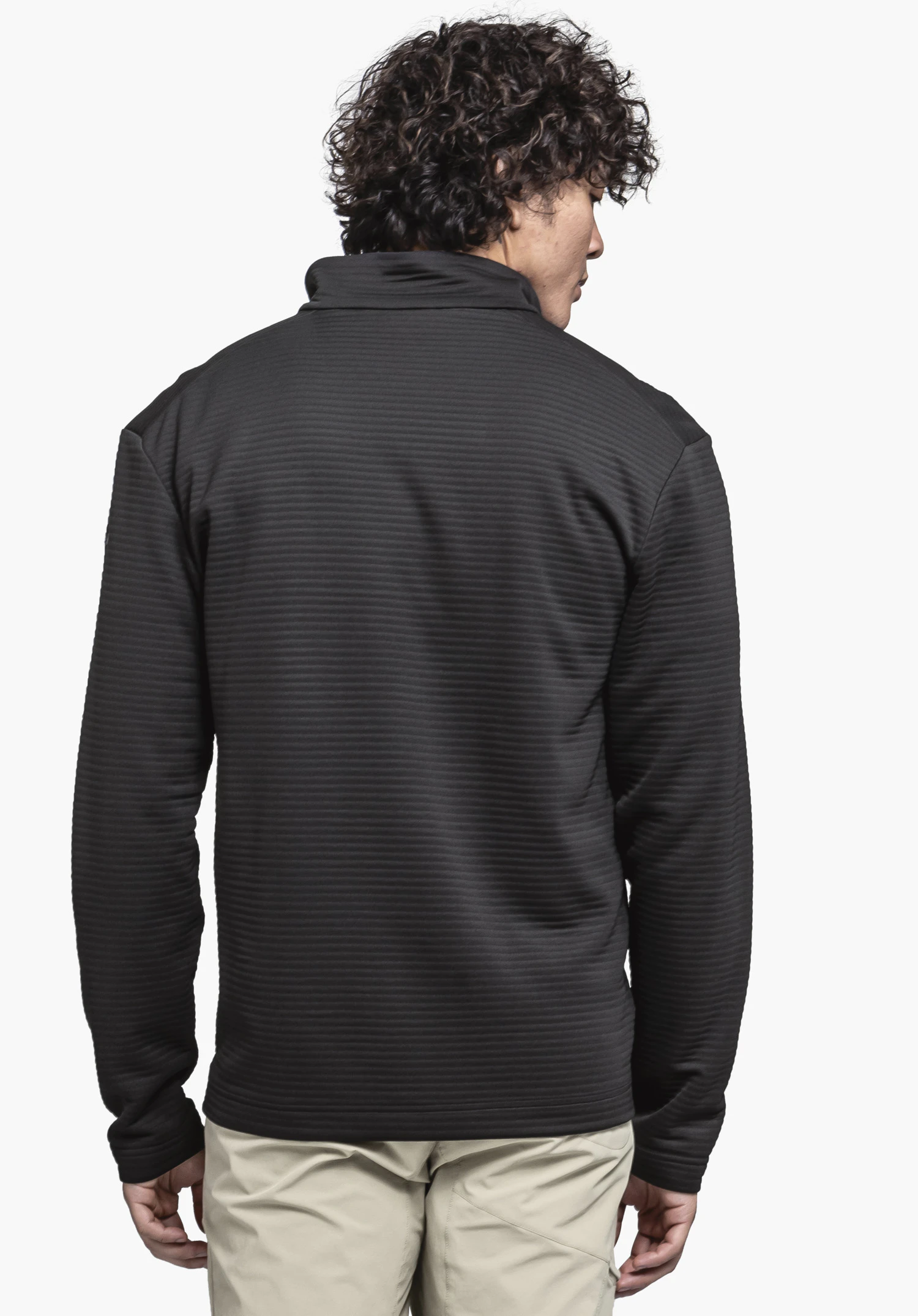 CIRC Fleece Jk Style Smue MNS. Ein Model zeigt in der Rückenansicht die schwarze Fleecejacke mit feiner Rippenstruktur vor einem neutralen Hintergrund.