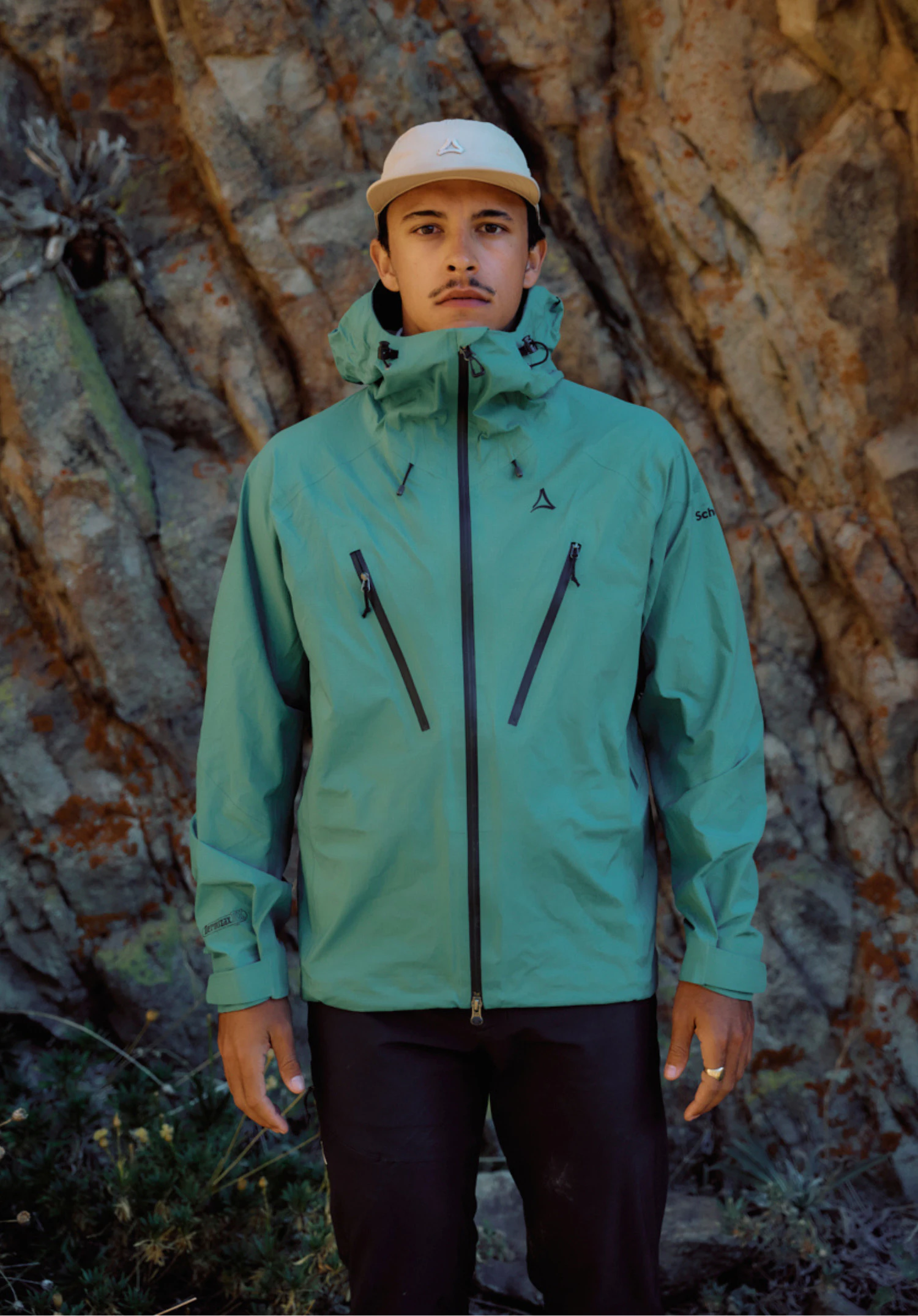 Jacket Style Blaueis MNS. You can see the green jacket with a closed zip, distinctive chest pockets and the Schöffel logo on the left chest. A model is wearing it, standing facing forwards against a neutral background.