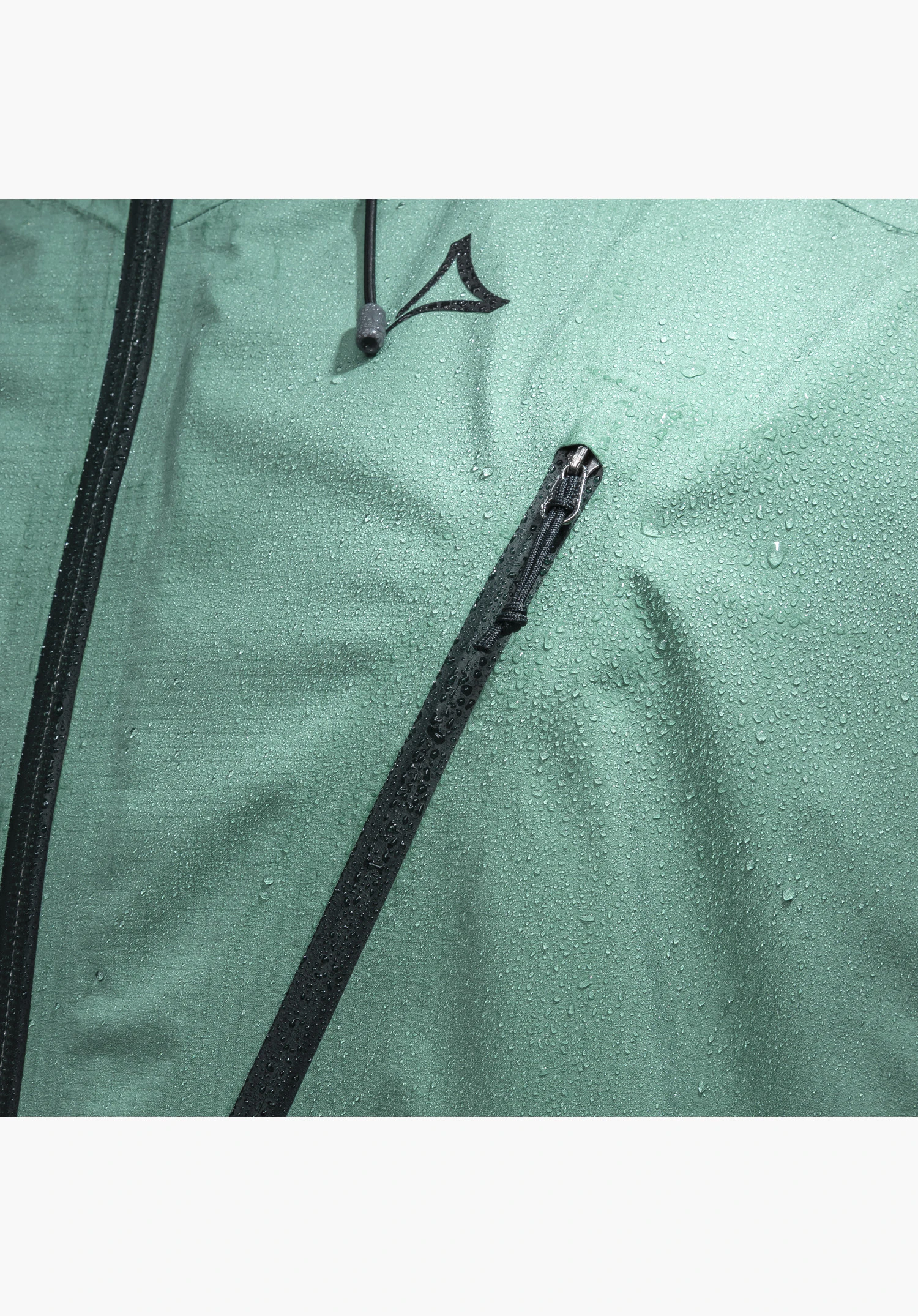 Jacket Style Blaueis MNS, detail of the green fabric with water droplets, a diagonal black zip, a front zip, a drawcord and the Schöffel logo, close-up against a white/neutral background.