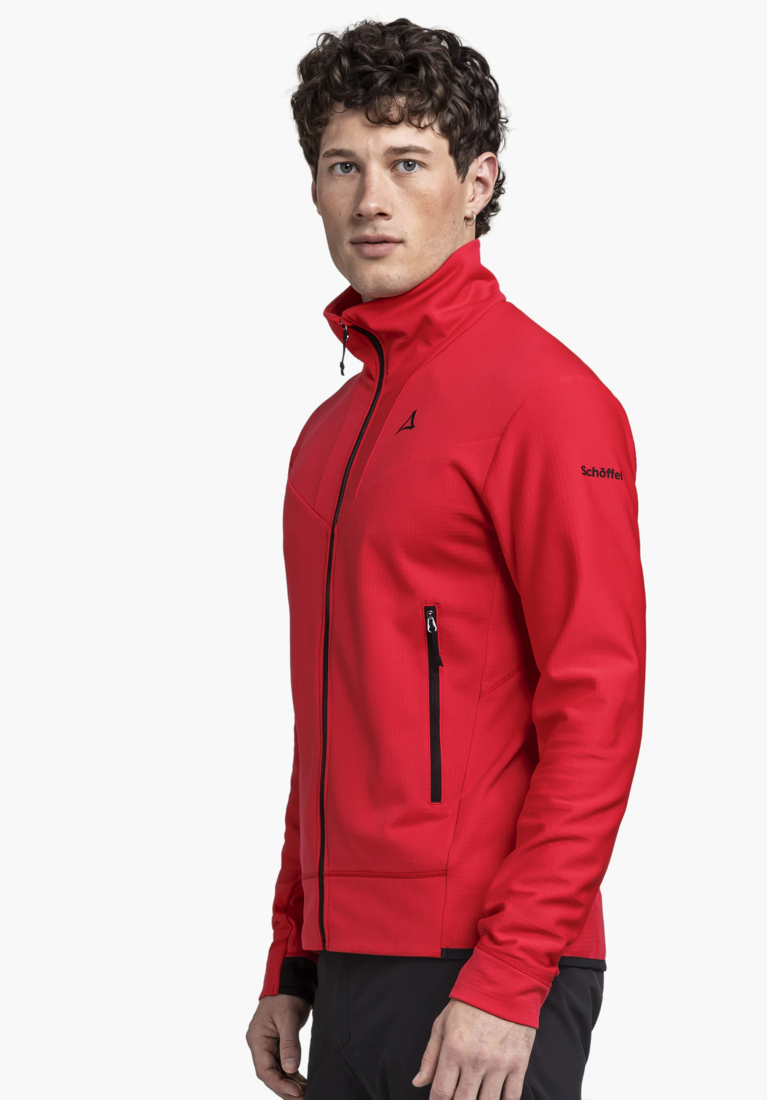 Fleece Jkt Style Blaueis MNS in Rot: Ein Model steht seitlich vor einem neutralen Hintergrund und präsentiert die Jacke, deren schwarze Reißverschlussdetails und das aufgedruckte Schöffel-Logo auf dem Oberarm deutlich erkennbar sind.