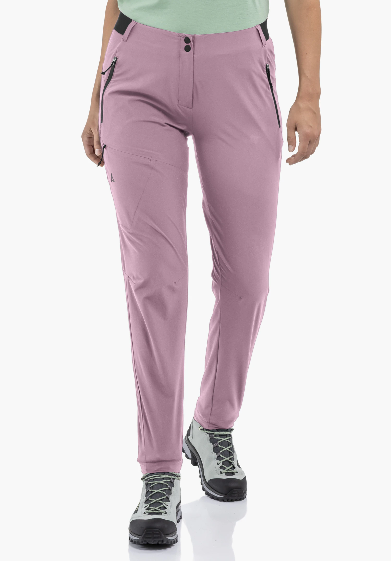 Pants Style Blaustein WMS worn by a model standing in a frontal position. The pink trousers with black zips on the side pockets and the Schöffel logo on the right leg are shown against a neutral background.