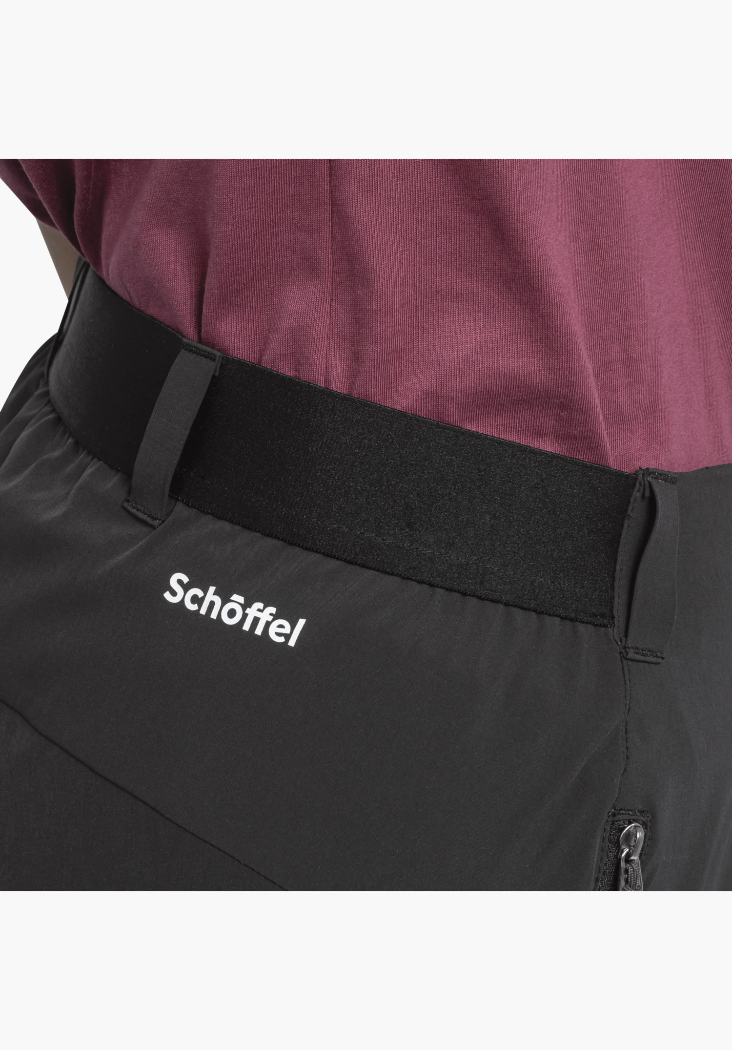 Pants Style Blaustein WMS zeigt den breiten schwarzen Bund mit Gürtelschlaufen, das weiße Schöffel-Logo auf dem Stoff und ein kleines Reißverschluss-Detail. Nahaufnahme vor weißem/neutralem Hintergrund.