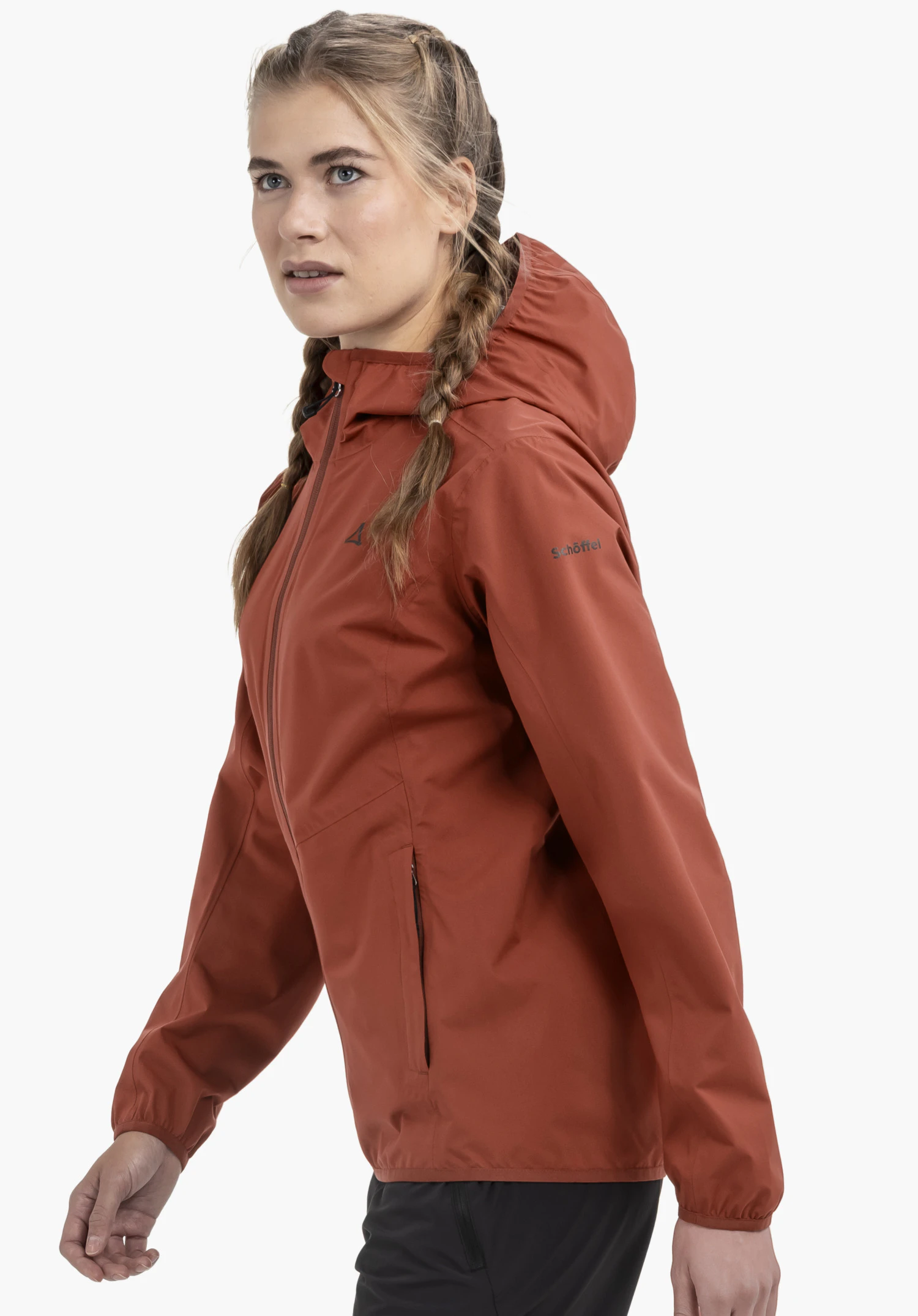 Jacket Style Migandi WMS worn by a model standing sideways. The red jacket with a hood and front zip features the Schöffel logo on the chest and left sleeve, presented against a neutral background.