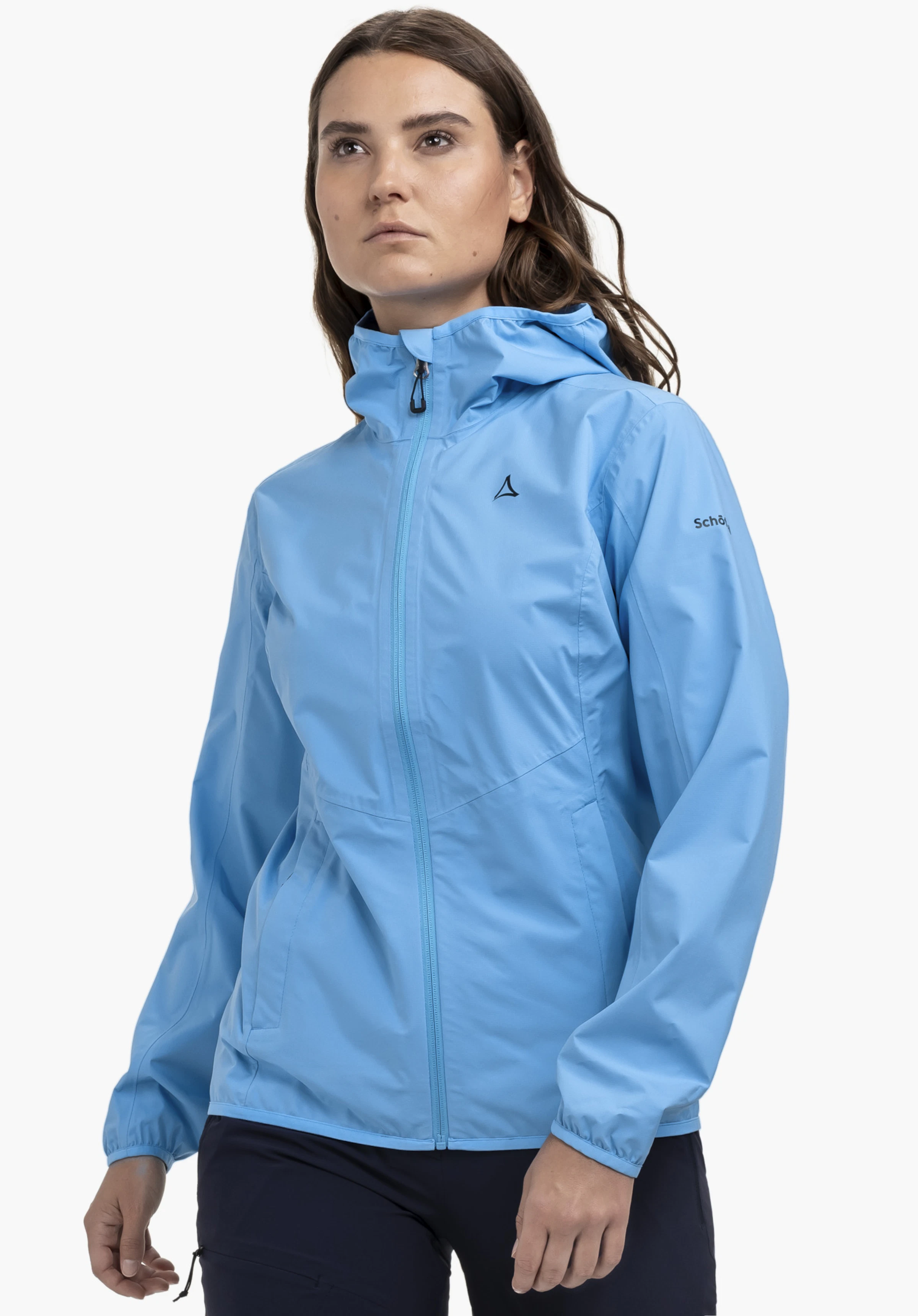 Jacket Style Migandi WMS an einem Model, das leicht seitlich steht. Die blaue Jacke zeigt das sichtbare Schöffel-Logo auf der Brust und am linken Ärmel, präsentiert vor einem neutralen Hintergrund.