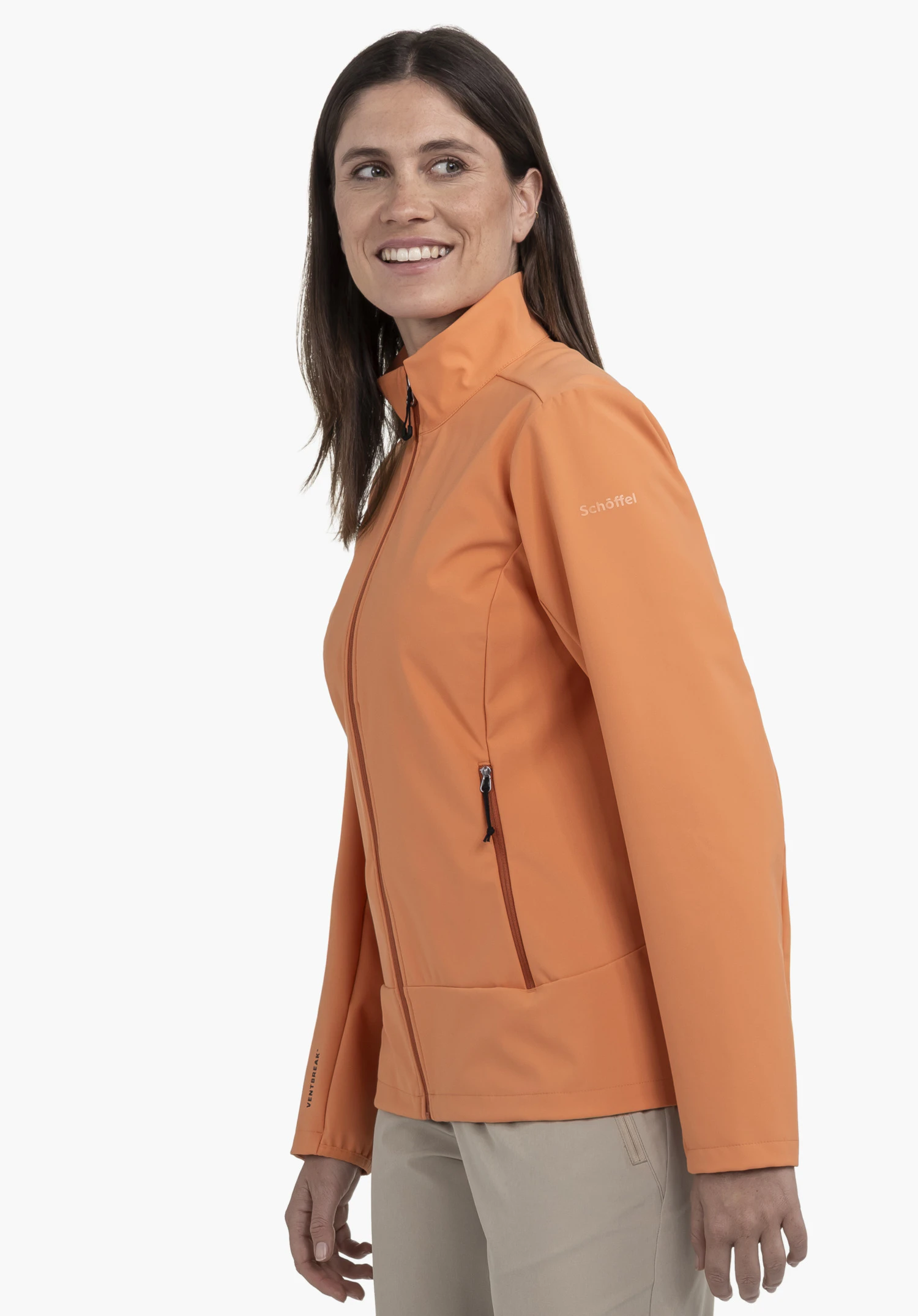 Softshell Jk Style Mirusha WMS in vibrant orange against a neutral background. The model is captured in a side-profile view, highlighting the subtle Schöffel logo on the left chest.