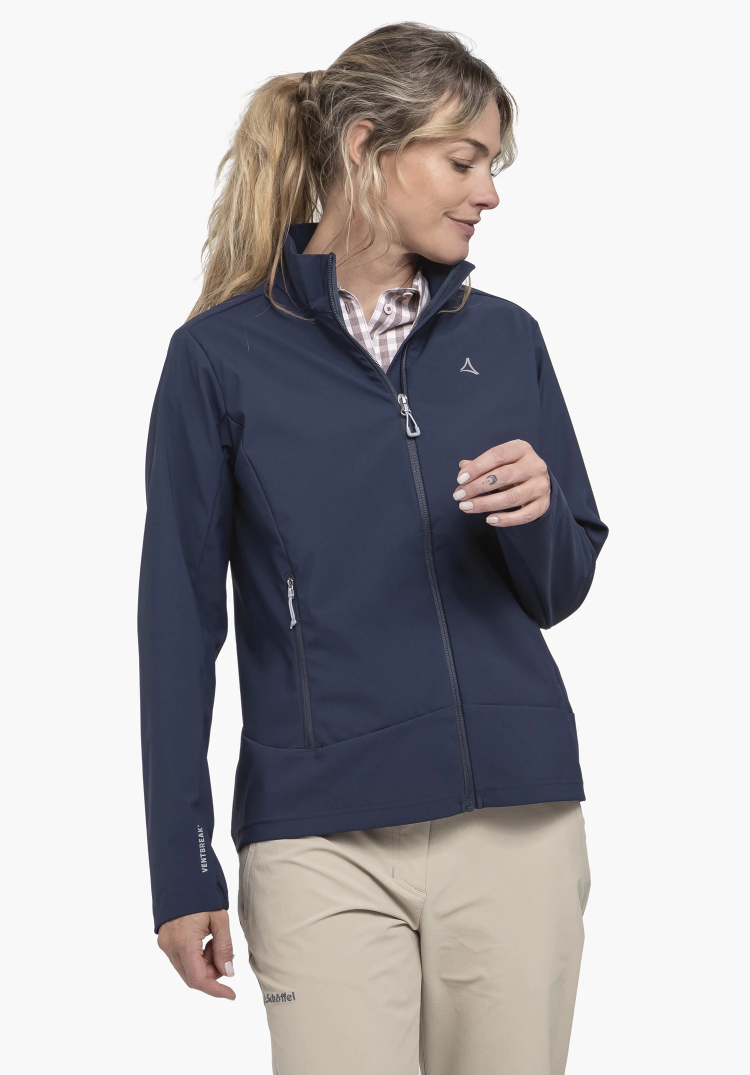 Softshell Jk Style Mirusha WMS an einem Model. Die Frau steht leicht seitlich und trägt die blaue Jacke vor einem neutralen Hintergrund. Auf der linken Brust ist das Schöffel-Logo zu sehen.