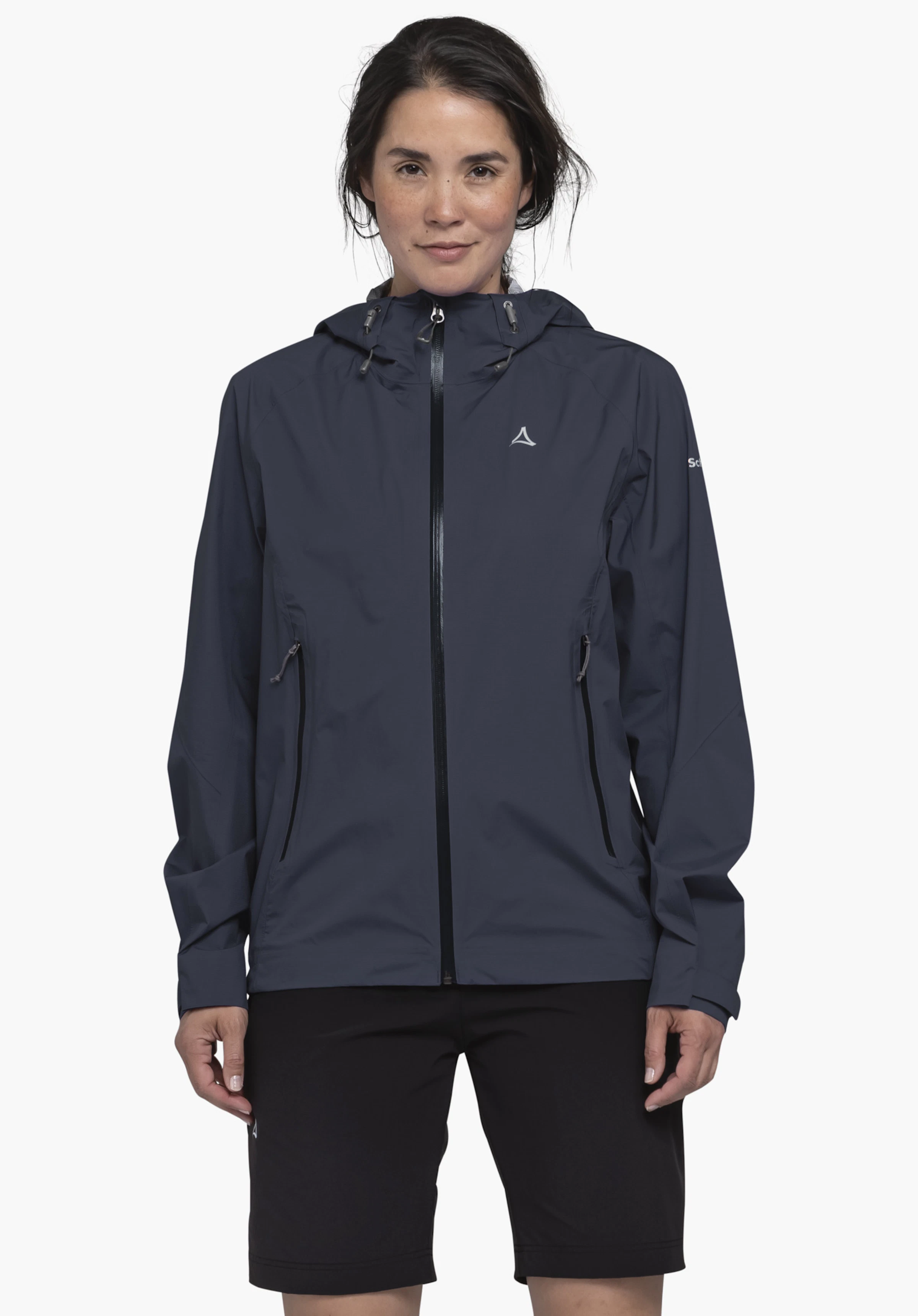 2.5L 3D Jacket Vistdal L sur un modèle qui se tient de face, portant la veste bleue avec le logo Schöffel visible sur la poitrine gauche, photographiée sur un fond neutre.