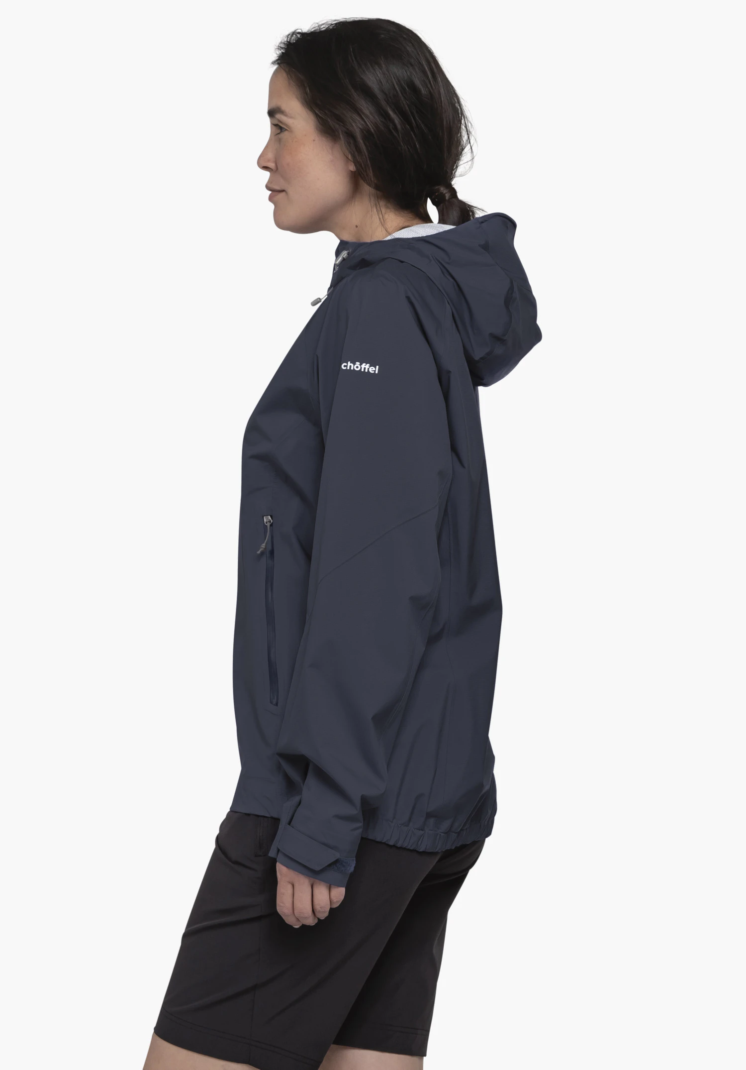 2.5L 3D Jacket Vistdal L en bleu. Le modèle pose de profil devant un fond neutre, présentant la veste avec sa capuche. Le logo Schöffel blanc est clairement visible sur le haut du bras, soulignant le look haut de gamme pour les aventures en plein air.