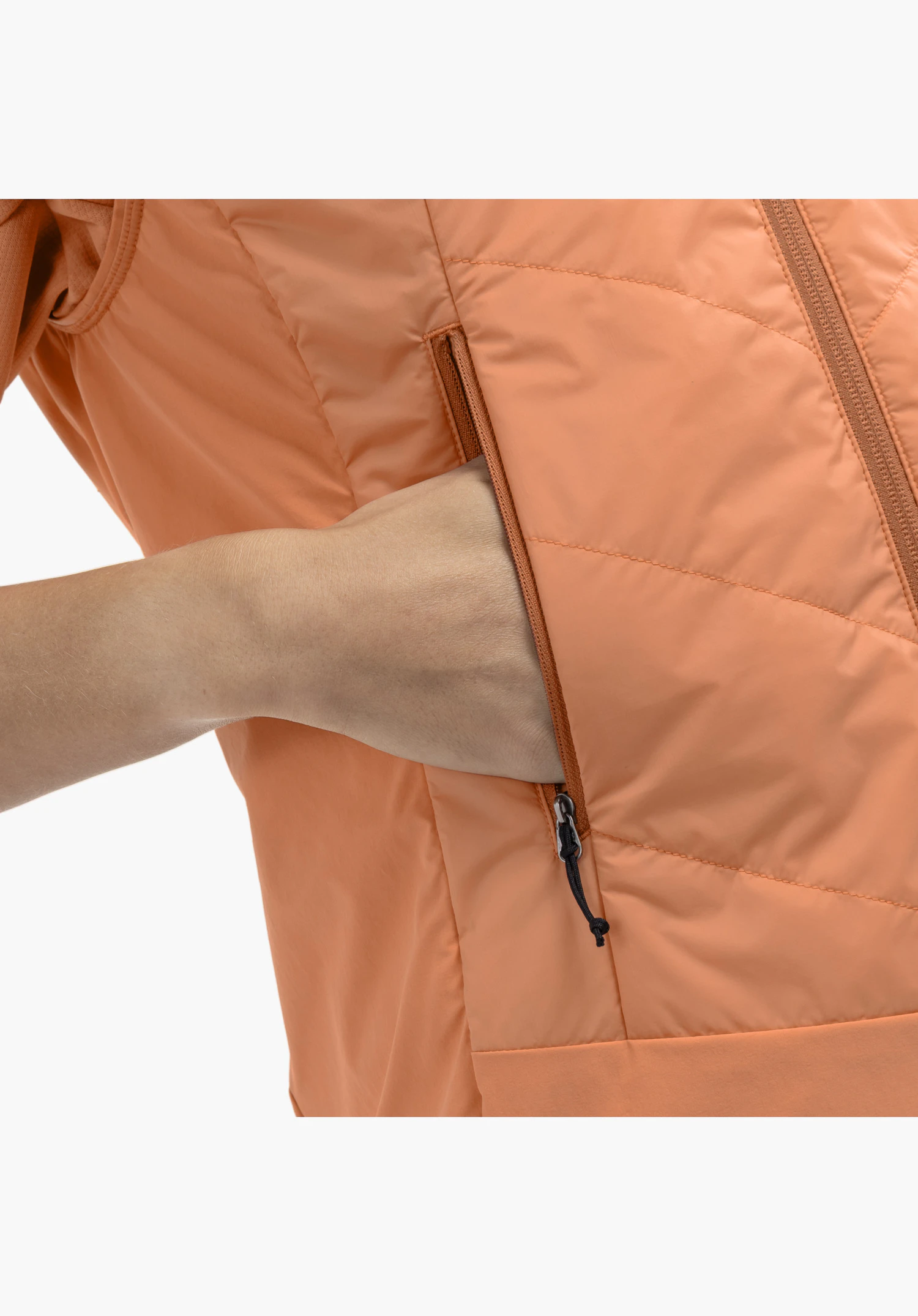Hybrid Vt Style Blaueis WMS : vue détaillée de la poche latérale dans le tissu orange avec une main glissée à l'intérieur, mettant en évidence la fermeture éclair et son petit cordon de tirage noir, gros plan sur fond blanc/neutre.