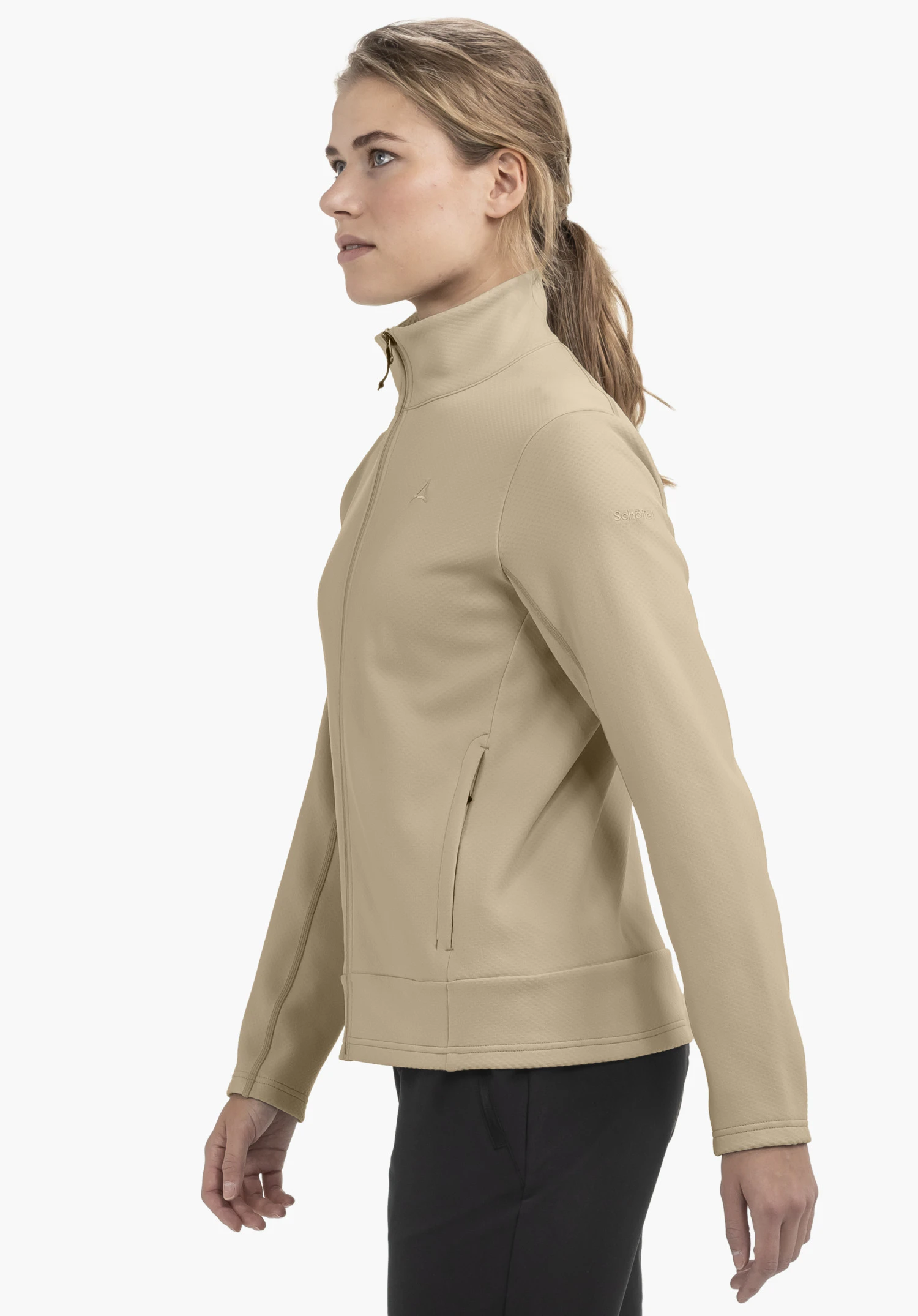 Fleece Jk Style Uriezzo WMS en beige, présenté par un mannequin dans une vue de profil devant un fond neutre. Cette veste en polaire se distingue par sa coupe ajustée et le logo Schöffel discrètement placé sur le haut du bras.