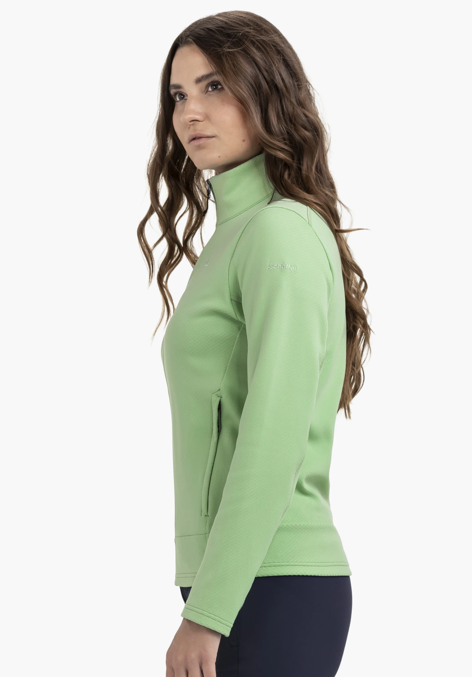 Fleece Jk Style Uriezzo WMS in green, worn by a model in a side profile shot against a neutral background. The high-quality design in green features a stand-up collar and the subtle Schöffel logo on the upper arm.