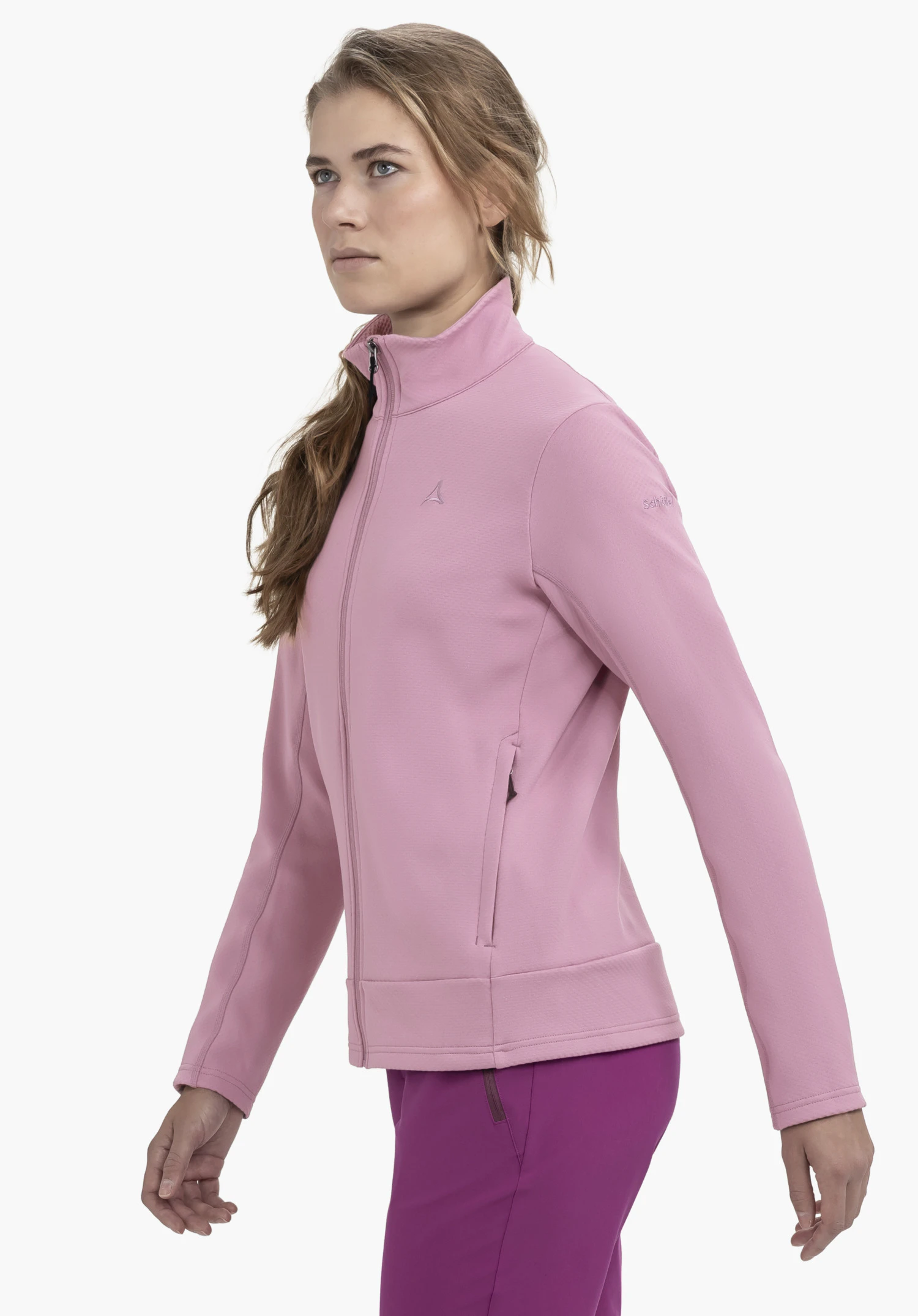Fleece Jk Style Uriezzo WMS in soft pink. The model is standing in a side profile view against a neutral background, wearing the fleece jacket with a high collar, showcasing the subtle Schöffel logo on the chest.
