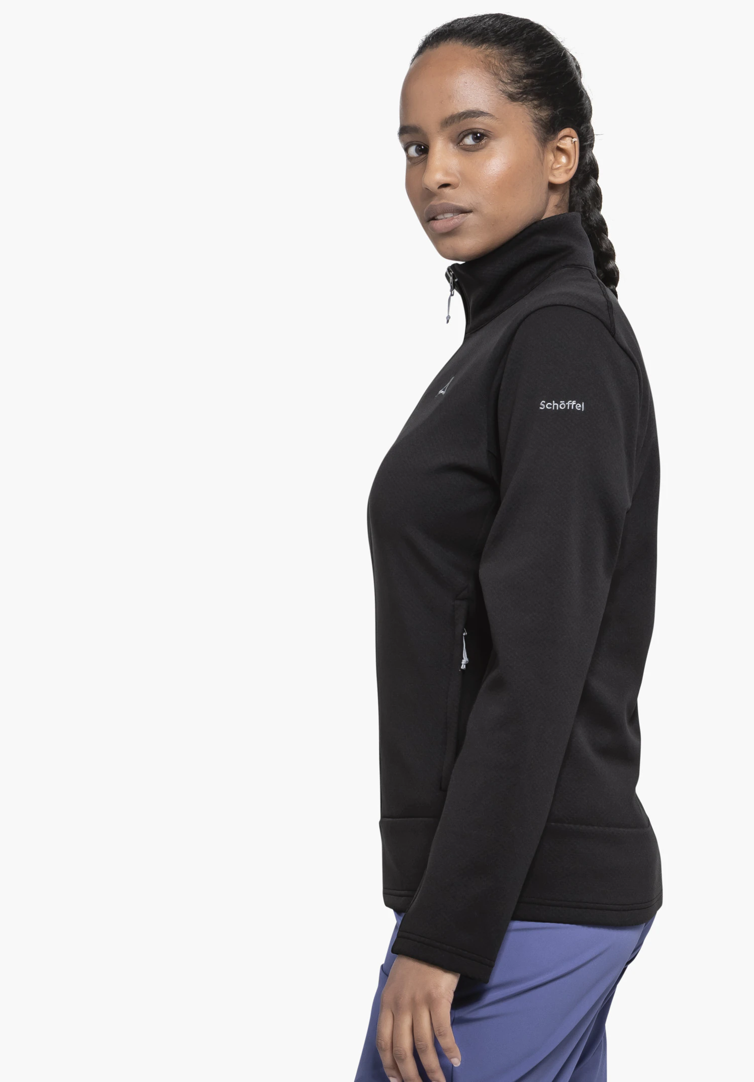 Fleece Jk Style Uriezzo WMS in black. The model is standing in a side profile against a neutral background, showcasing the jacket with the white Schöffel logo clearly visible on the upper arm.