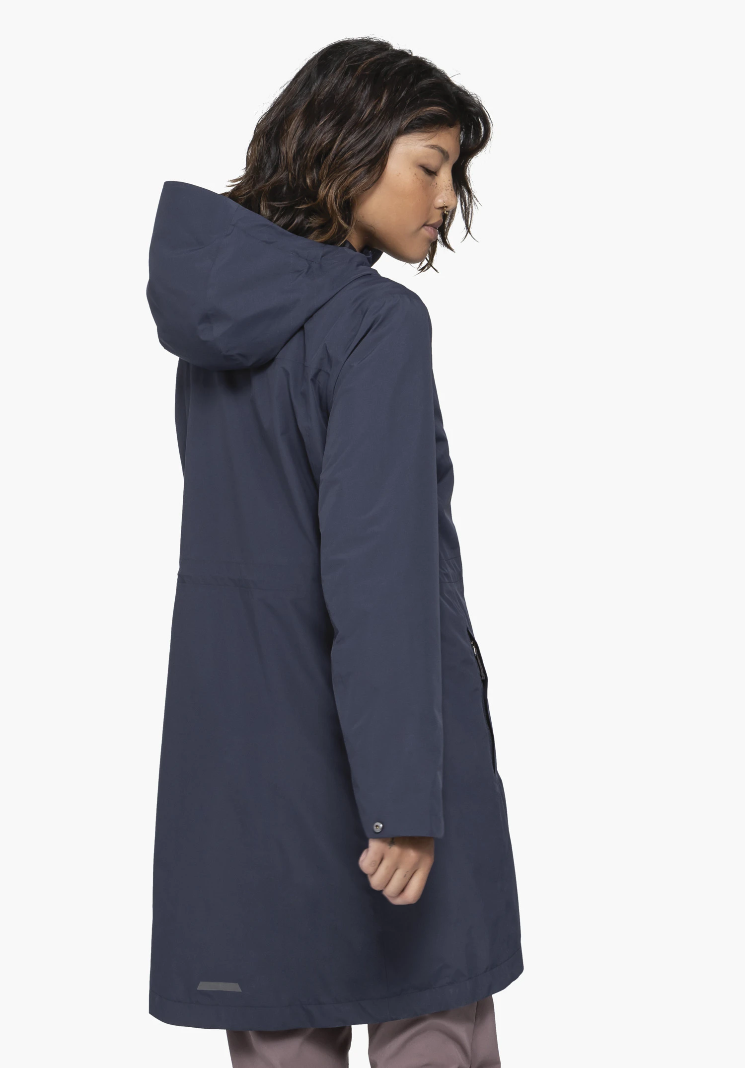Coat Style Bohorok WMS worn by a model standing sideways in a back view. The long blue coat with a hood is shown against a neutral background.