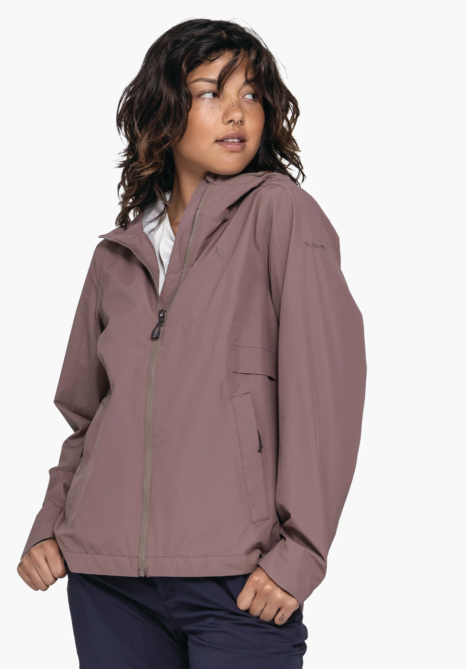 Jacket Style Bohorok WMS in brown. A model is wearing the jacket against a neutral background, posing while looking slightly to the side. The subtle Schöffel logo is visible on the chest and the sleeve.