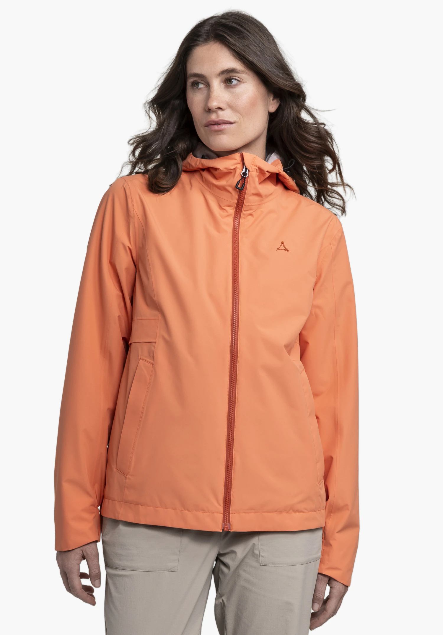 Jacket Style Bohorok WMS in der Farbe Orange. Eine Frau präsentiert die Jacke frontal vor einem neutralen Hintergrund. Die Jacke zeigt das diskrete Schöffel-Logo auf der Brust und einen durchgehenden Reißverschluss.