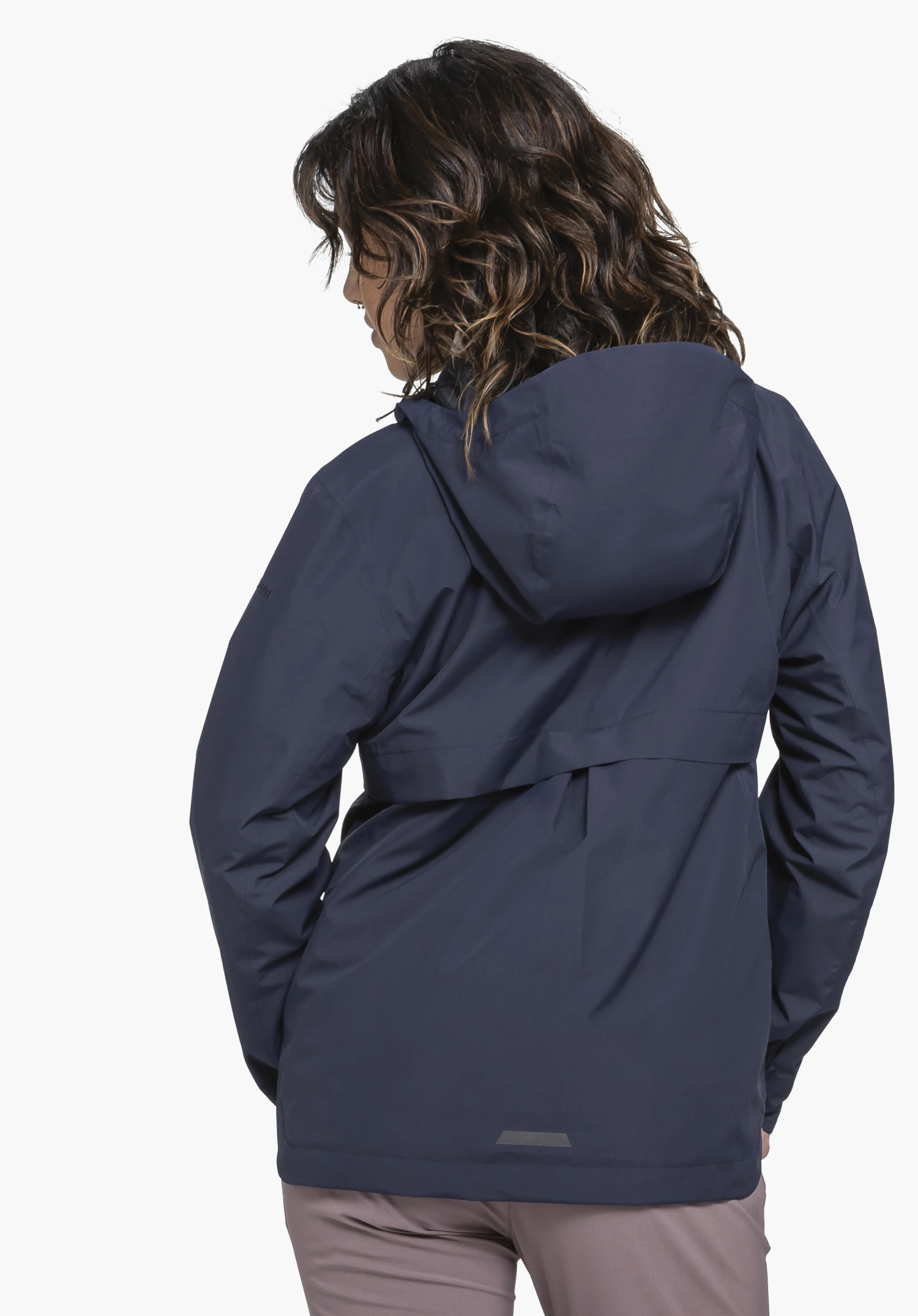 Jacket Style Bohorok WMS in blue. The model presents the jacket from a back view, clearly showing the generous hood and the Schöffel logo on the left sleeve. She stands in front of a neutral background.