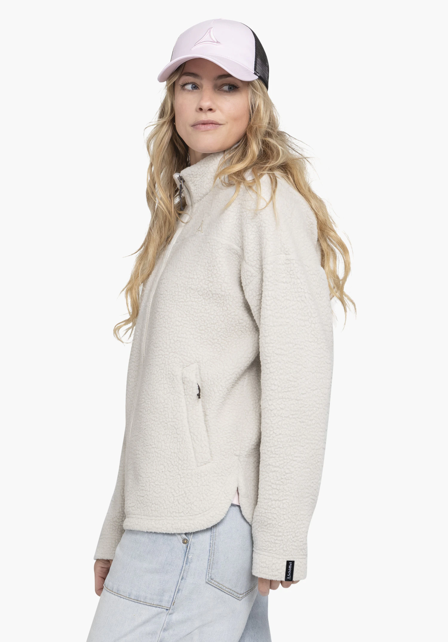 CIRC Fleece Jk Style Purga WMS in the colour natur. A model stands sideways and presents the fluffy fleece jacket with a high collar and Schöffel logo on the sleeve hem against a neutral background.