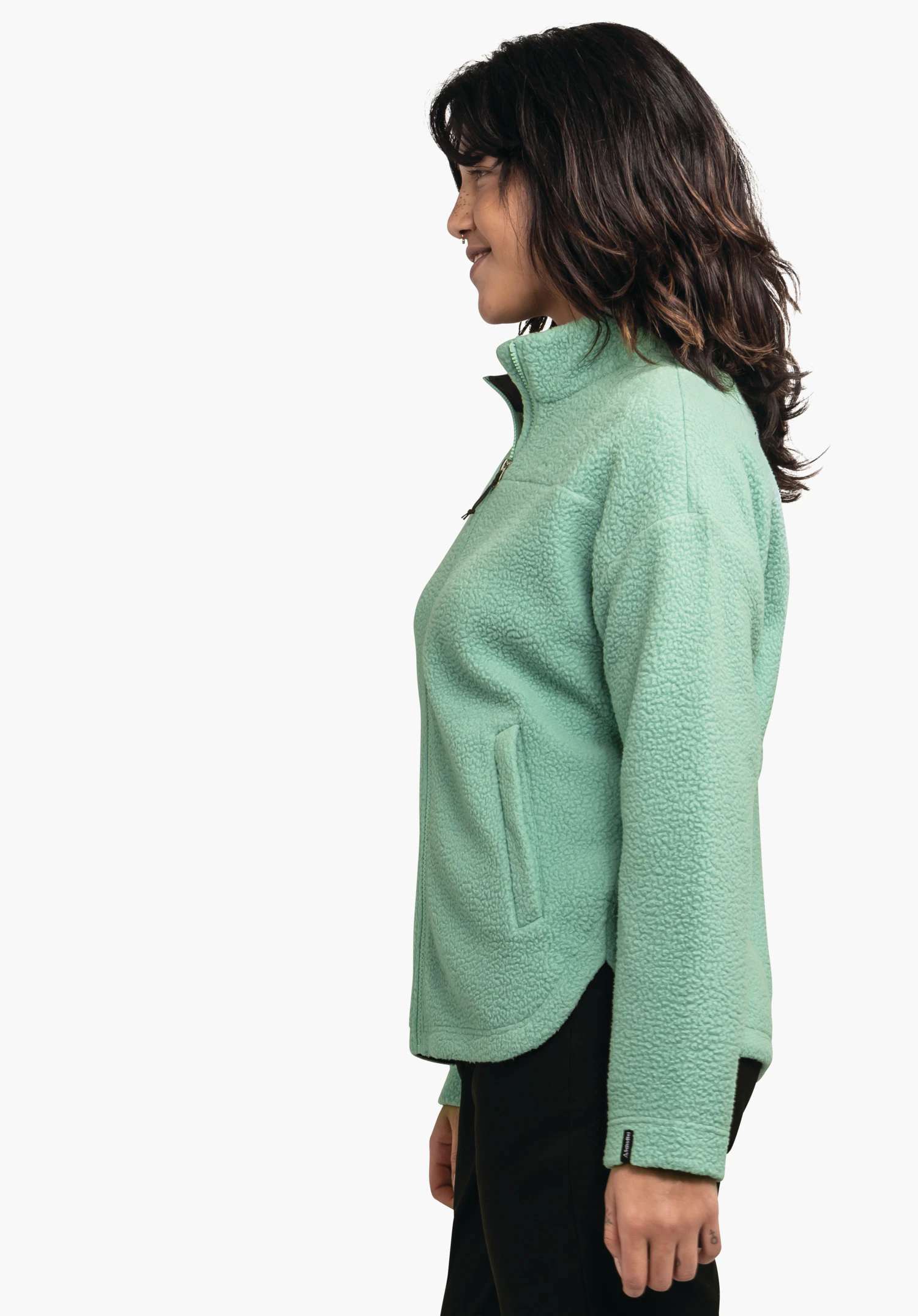 CIRC Fleece Jk Style Purga WMS veste polaire vert clair portée de profil par un modèle souriant; pantalon noir, polaire douce avec col montant, fond blanc neutre.