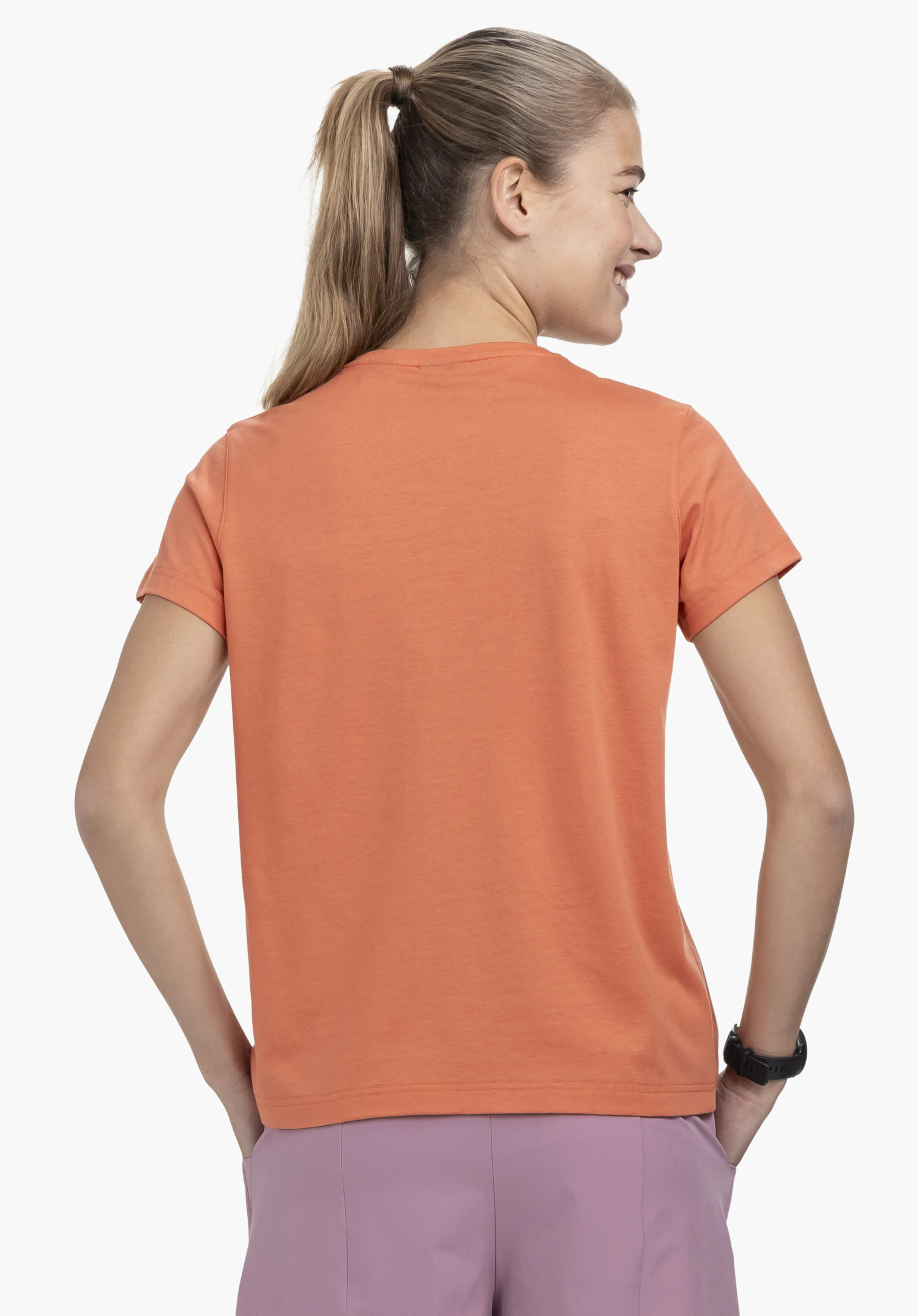 T Shirt Style Collada WMS in orange presents a back view of a woman against a neutral background, highlighting the clean fit and design.