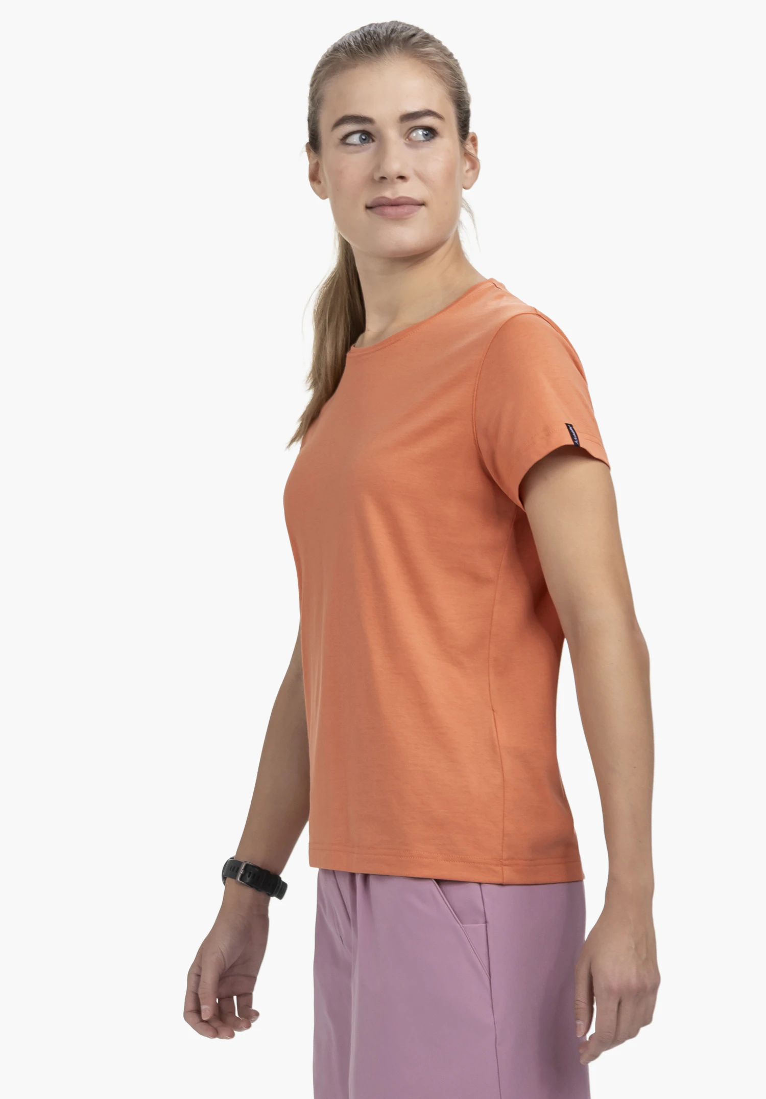 T Shirt Style Collada WMS in orange. The model stands sideways, presenting the t-shirt with a small Schöffel logo on the sleeve against a neutral background.