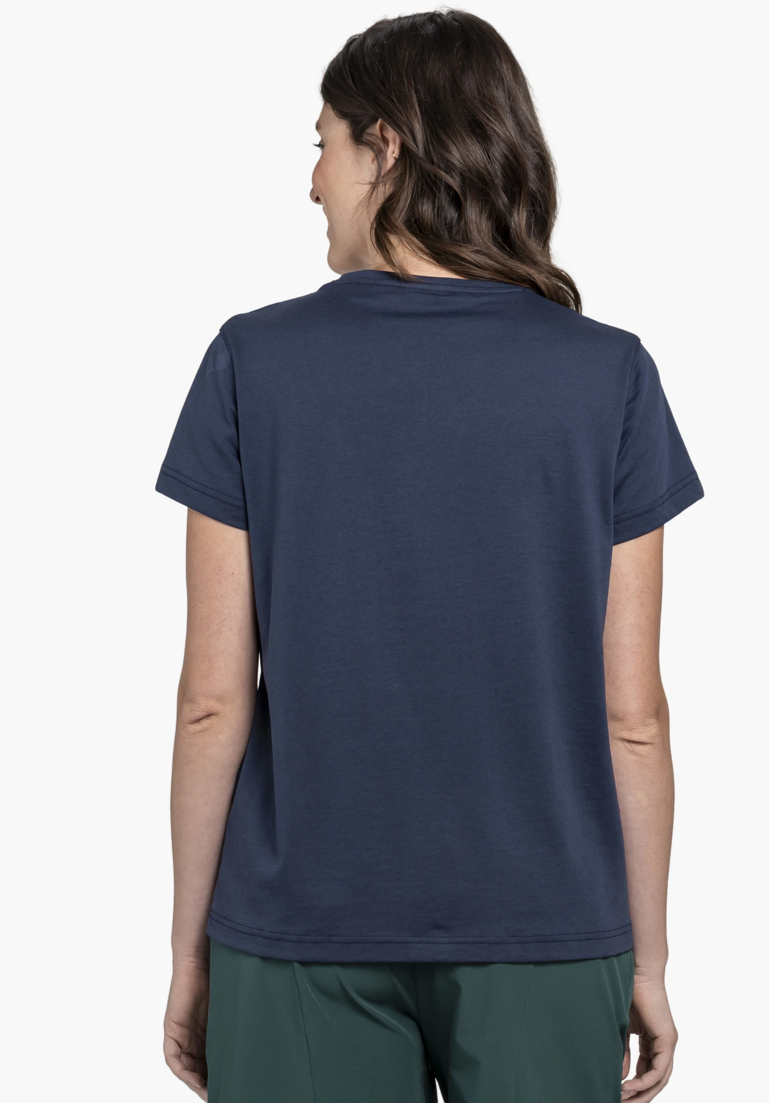 T Shirt Style Collada WMS in Blau zeigt sich hier in der Rückenansicht. Die Frau präsentiert das T-Shirt vor einem neutralen Hintergrund, wobei der cleane Look ohne sichtbares Schöffel-Logo im Fokus steht.