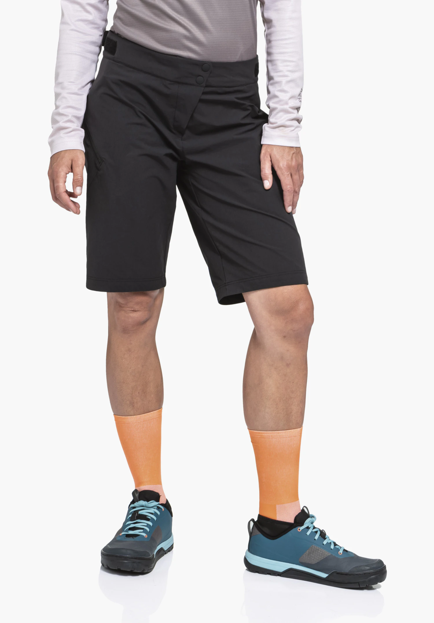 Shorts Style Puula WMS black shorts; person stands with arms at sides, wearing orange socks and dark blue shoes; white studio background.
