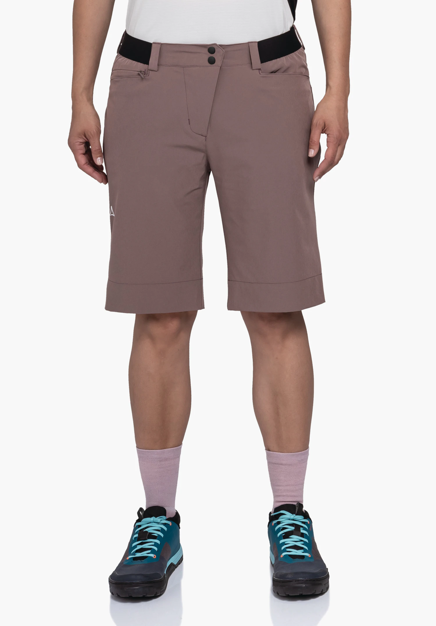 Shorts Style Keitele WMS on a model standing front-on. You can see the brown shorts worn with a white top, pink socks and blue shoes, as well as a laterally visible Schöffel logo against a neutral background.