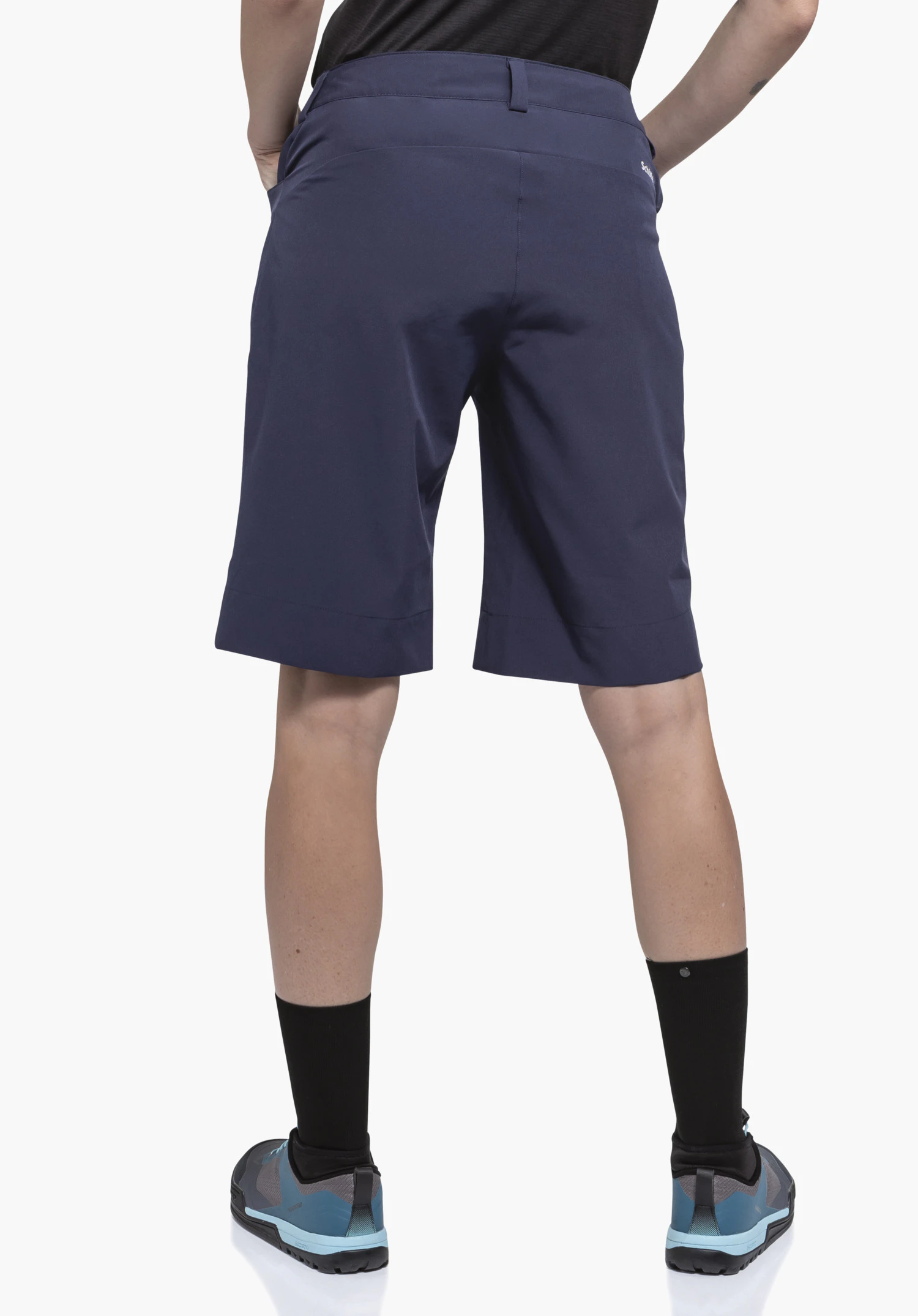 Shorts Style Keitele WMS in het blauw. Het model staat in een rugaanzicht en toont de achterkant van de korte broek met het Schöffel-logo zichtbaar aan de rechterkant tegen een neutrale achtergrond.
