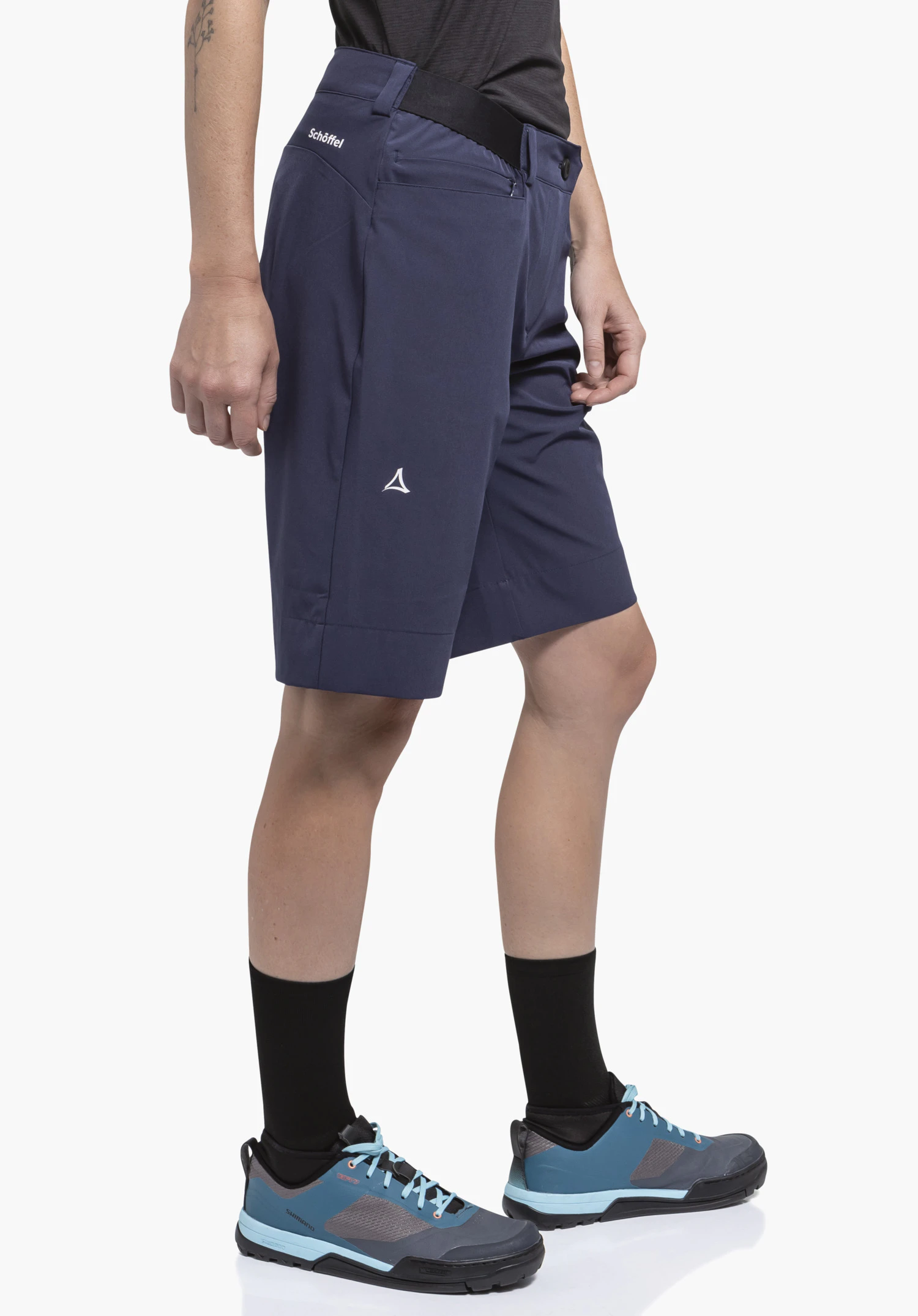 Shorts Style Keitele WMS in blauw. Het model presenteert de shorts in een zijaanzicht voor een neutrale achtergrond. Details zoals het subtiele Schöffel-logo op de dij benadrukken de functionele look voor sportieve activiteiten.