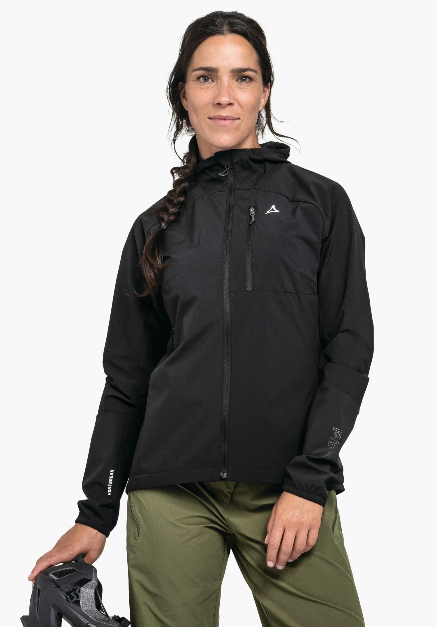 Hybrid Jk Style Mamry WMS in black. The model stands frontally, looking at the camera, showcasing the zipped jacket with a visible Schöffel logo on the left chest. She holds a bicycle helmet in her right hand, photographed against a neutral background.