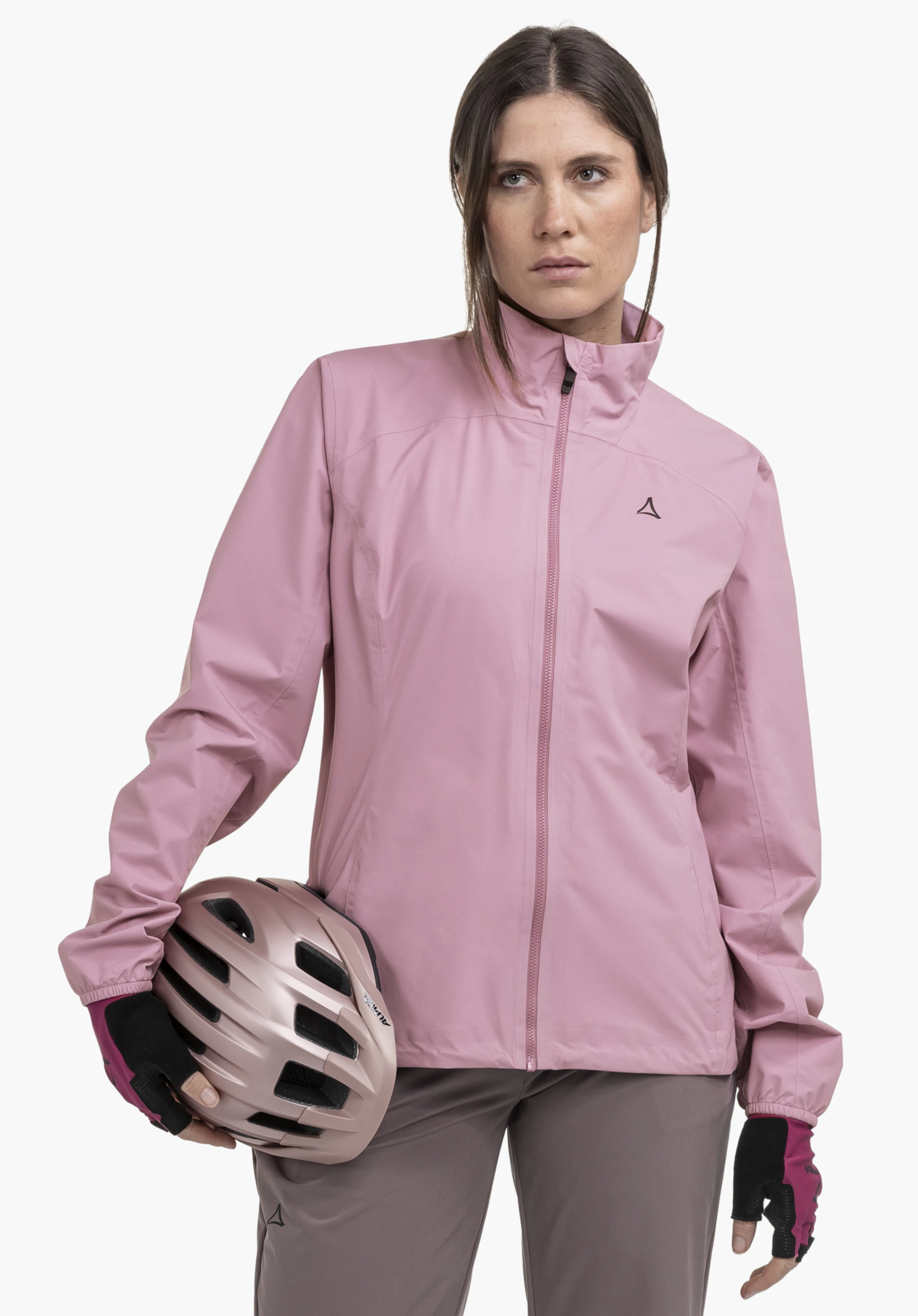 Jacket Style Lurbek WMS op een model dat frontaal staat, met een fietshelm onder haar arm. De roze jas laat duidelijk het Schöffel-logo op de linkerborst zien. Gepresenteerd tegen een neutrale achtergrond.