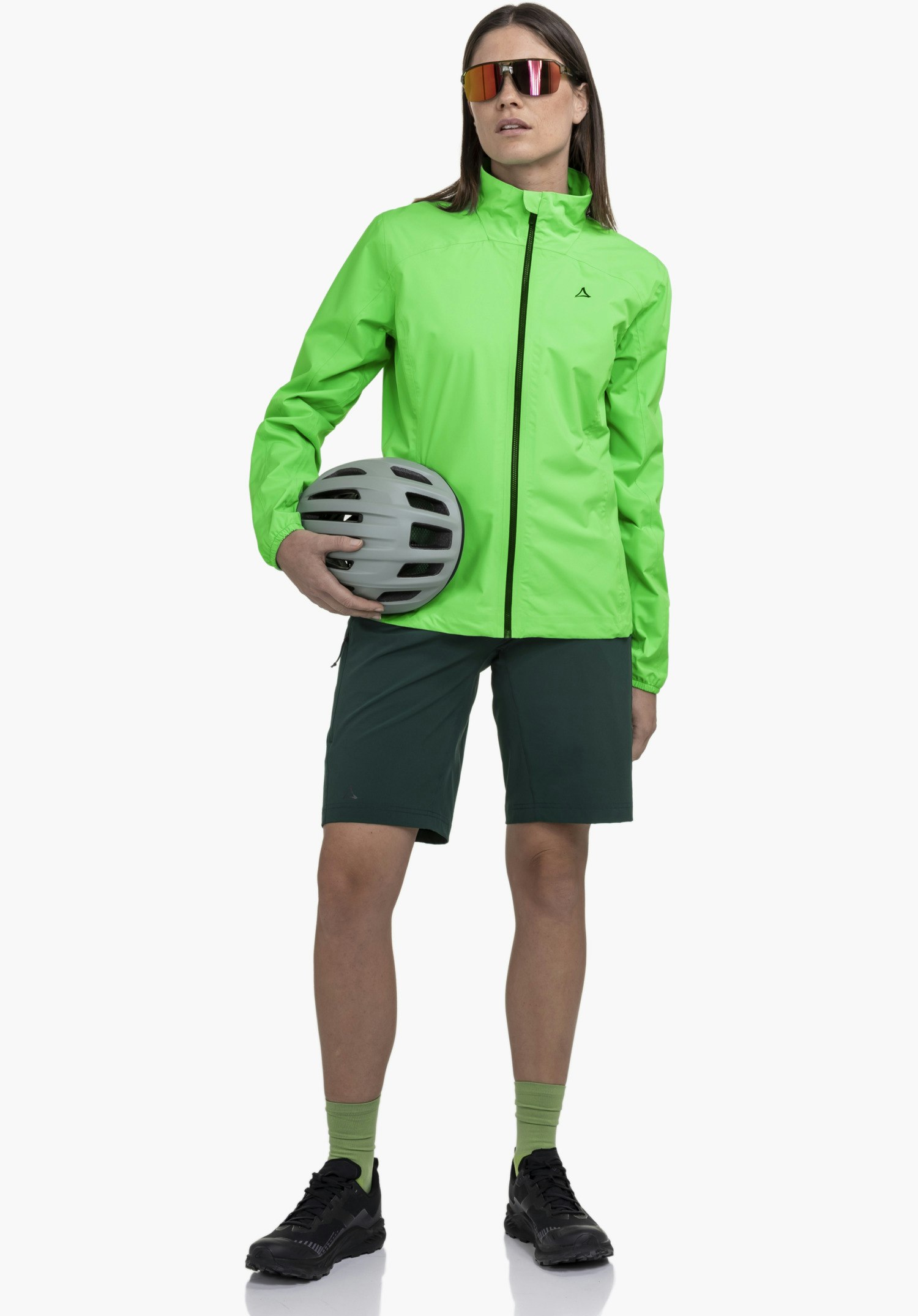 Jacket Style Lurbek WMS. Im Fokus stehen der kontrastierende schwarze Reißverschluss und das dunkle Schöffel-Logo auf dem glatten, grünen Stoff, Nahaufnahme vor weißem Hintergrund.