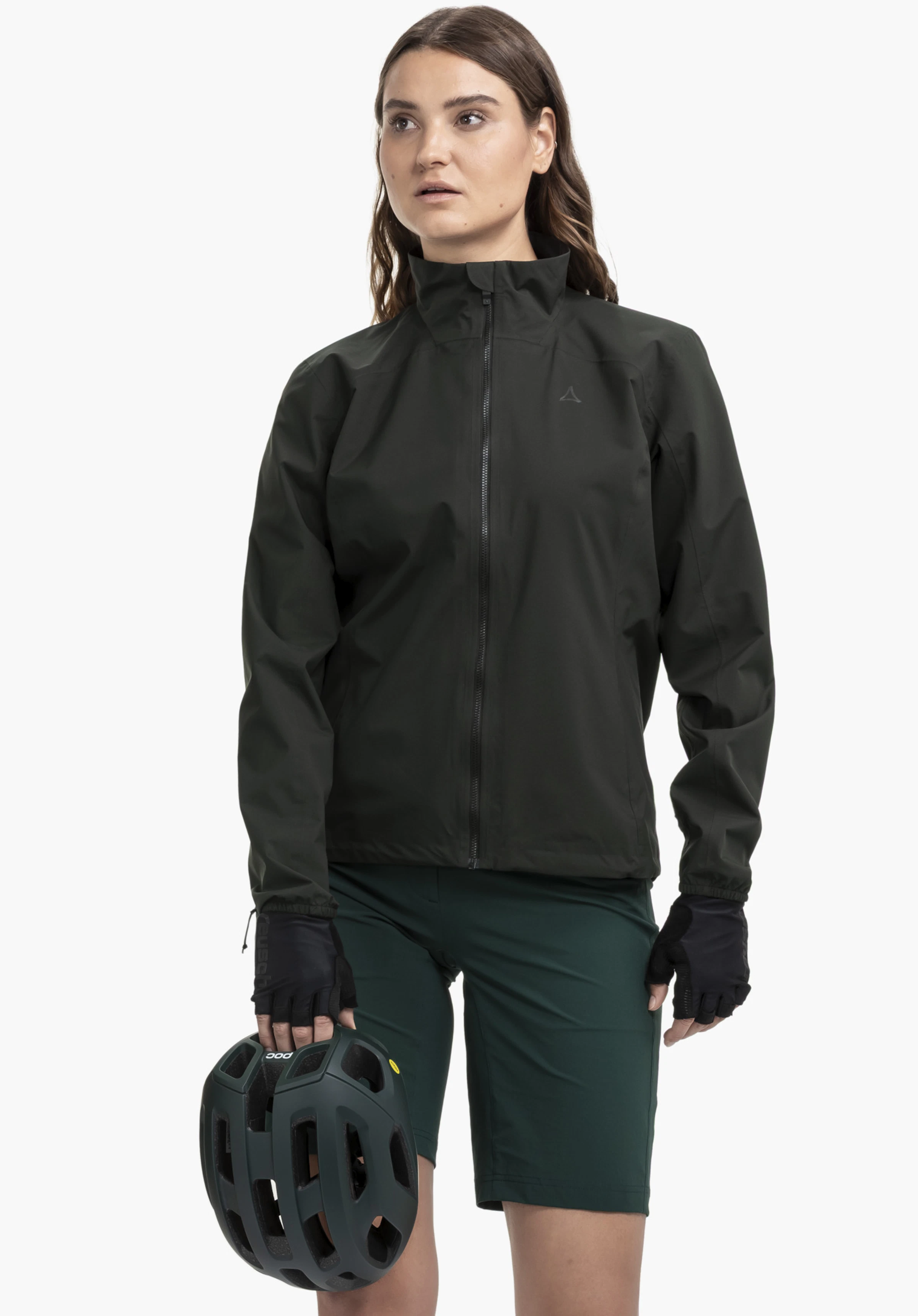 Jacket Style Lurbek WMS sur un mannequin se tenant de face et tenant un casque de vélo. La veste est présentée en noir avec le logo Schöffel sur la poitrine gauche devant un fond neutre.