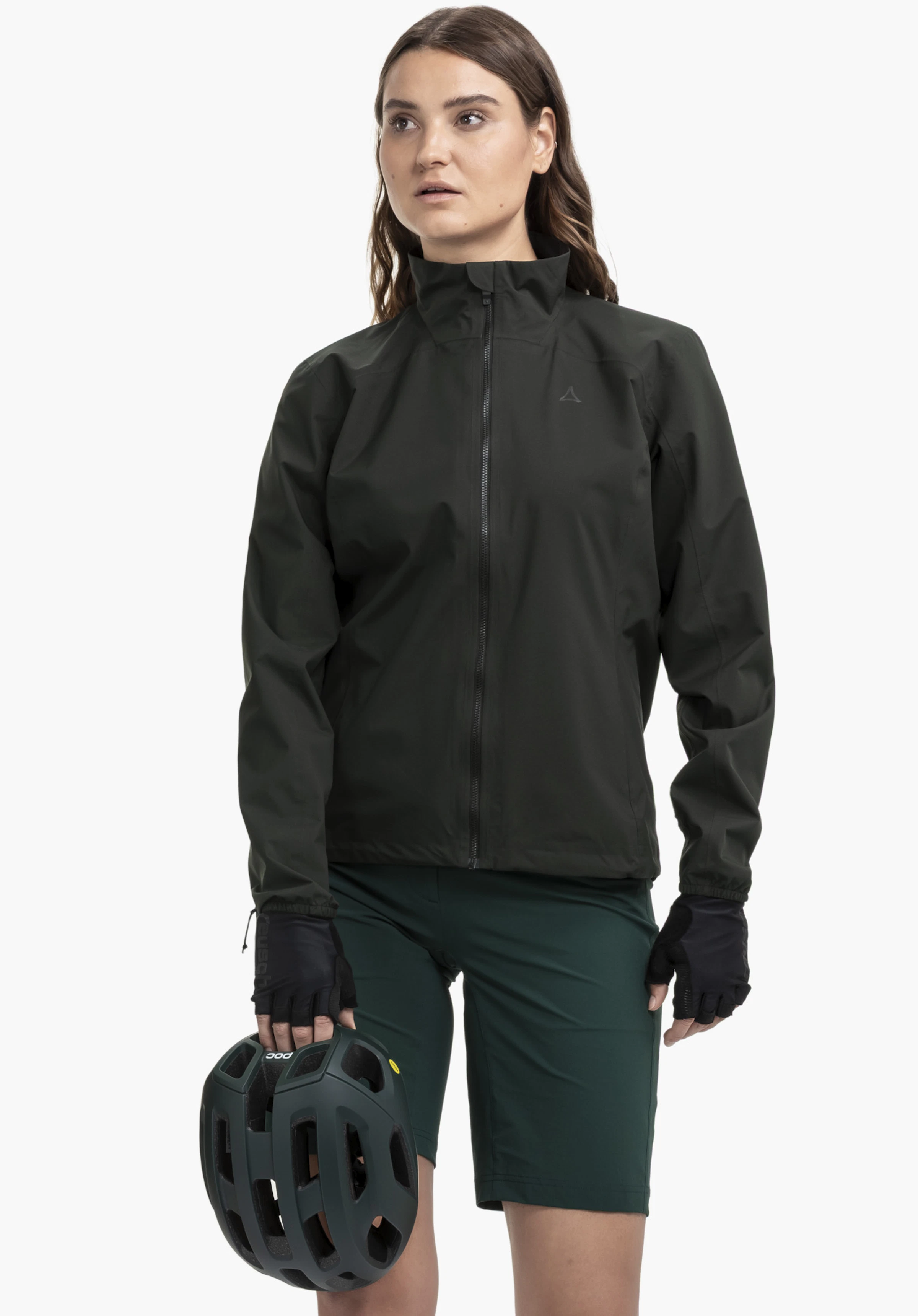 Jacket Style Lurbek WMS an einem Model, das frontal steht und einen Fahrradhelm hält. Man sieht die Jacke in schwarz mit dem Schöffel-Logo auf der linken Brust vor einem neutralen Hintergrund.
