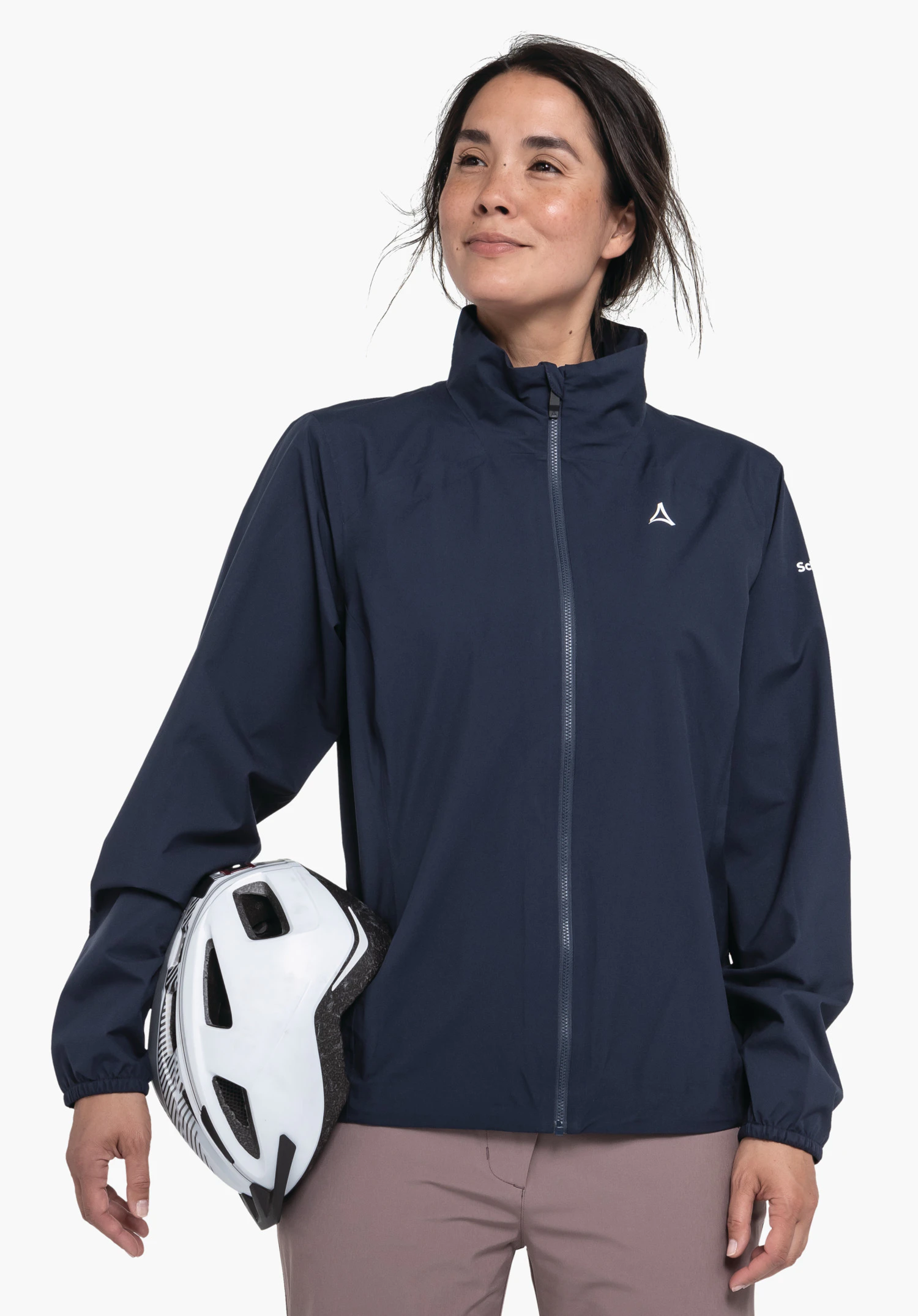 Jacket Style Lurbek WMS dunkelblaue Jacke mit Schöffel-Logo, Person hält weißen Fahrradhelm seitlich, stehend vor weißem Hintergrund; Text auf Ärmel: "Schöffel".