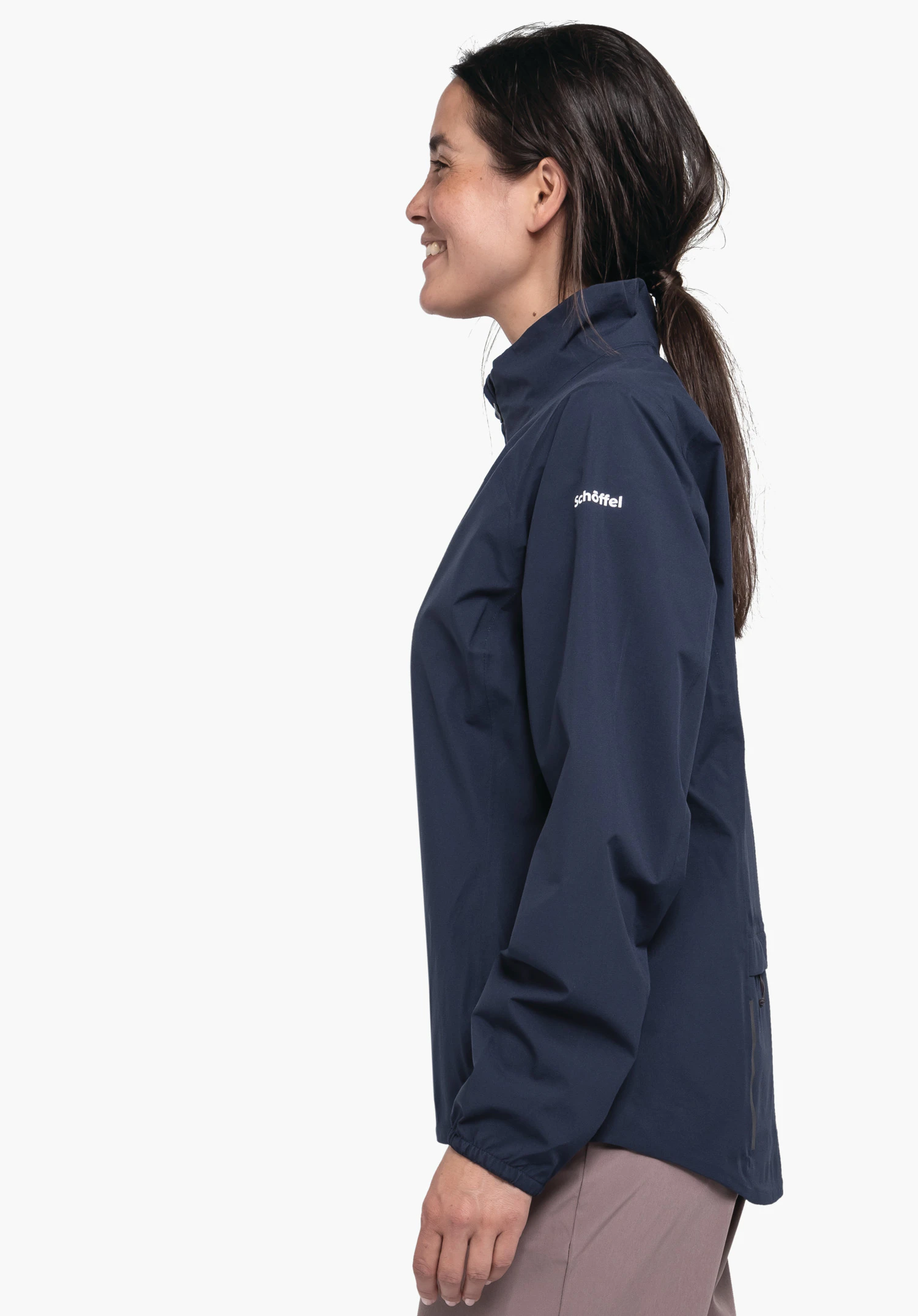 Jacket Style Lurbek WMS Dunkelblaue Jacke, von einer Frau seitlich getragen, lächelnd stehend; Ärmelaufdruck: "schöffel"; neutraler weißer Studiohintergrund.