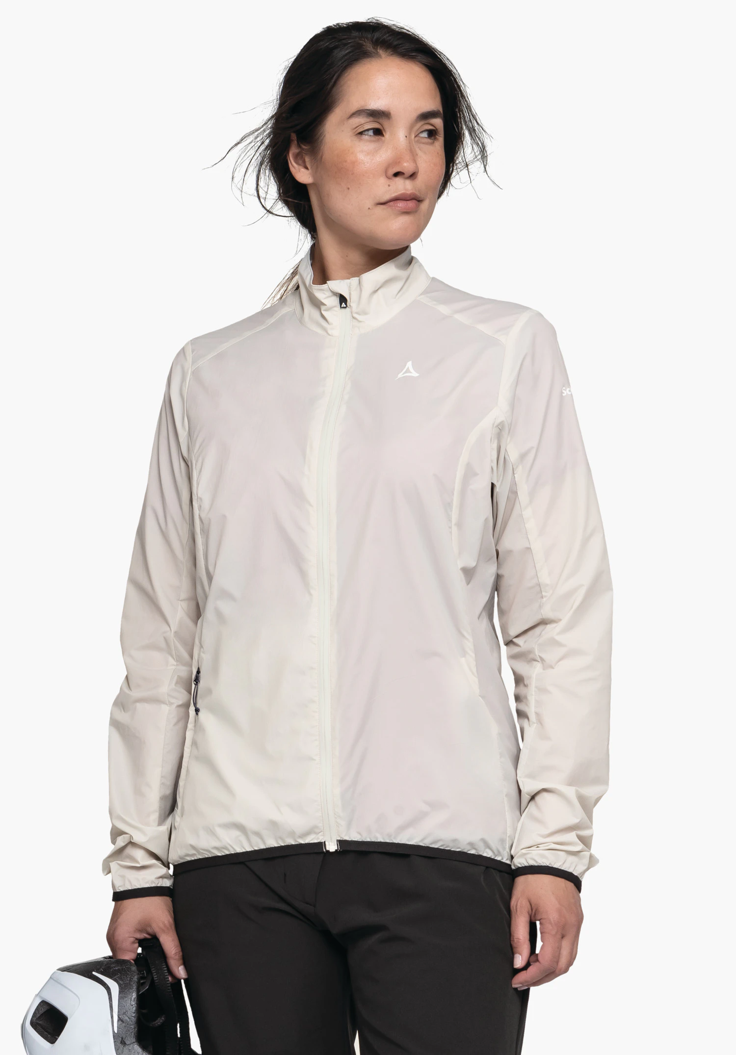 Jacket Style Cannobio WMS veste coupe-vent légère blanc clair, portée par une personne debout; logo Schöffel sur la poitrine; personne tenant un casque blanc dans la main gauche; fond blanc neutre.
