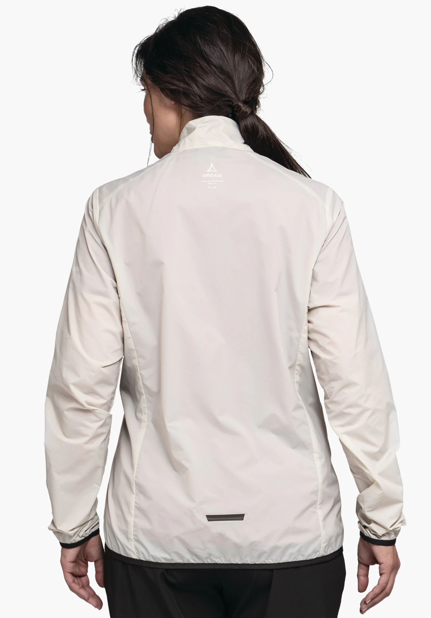 Jacket Style Cannobio WMS veste imperméable blanc clair, portée, vue arrière; modèle debout devant un fond blanc. Logo Schöffel centré en haut avec inscription "Schöffel". Bande réfléchissante noire en bas du dos.