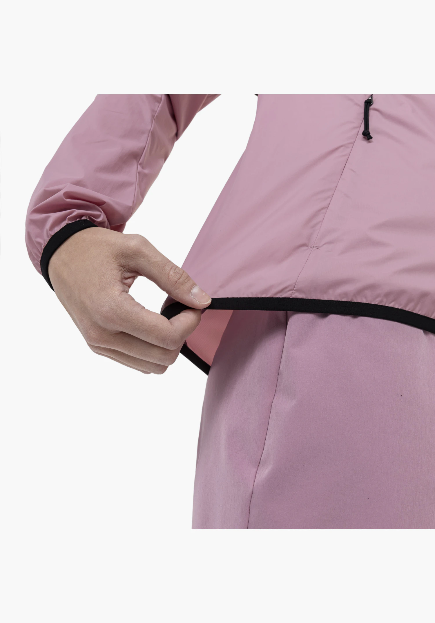 Jacket Style Cannobio WMS, Detail des elastischen schwarzen Saumabschlusses am rosa Stoff, der von einer Hand gedehnt wird, als Nahaufnahme vor weißem Hintergrund.
