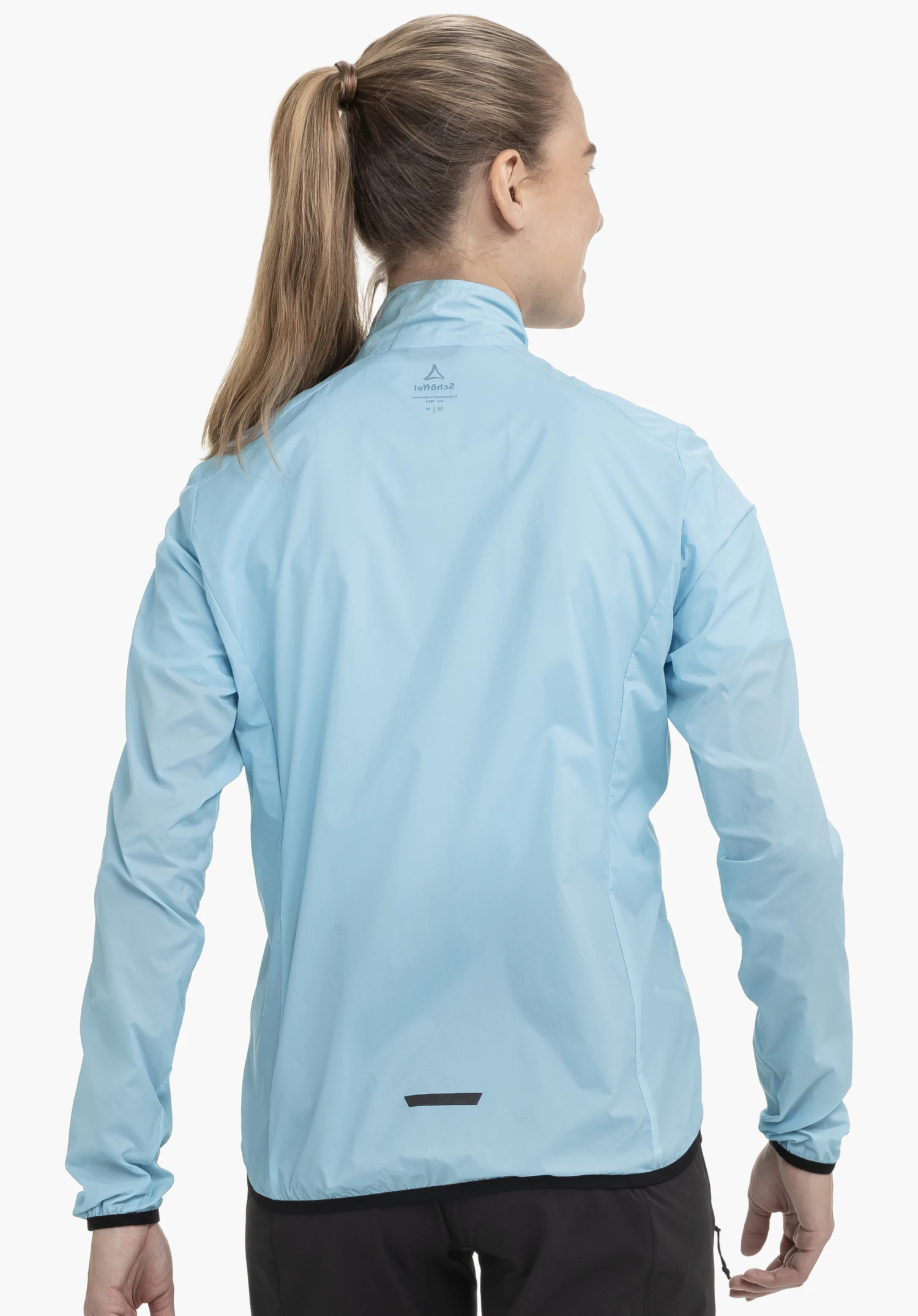Jacket Style Cannobio WMS in Blau zeigt sich in der Rückenansicht an einem Model vor neutralem Hintergrund, wobei das Schöffel-Logo im Nackenbereich gut sichtbar ist.