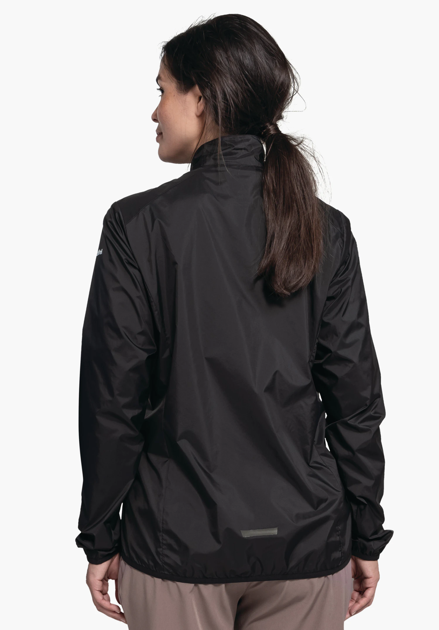 Jacket Style Cannobio WMS portée par un mannequin vu de dos. La veste noire laisse apercevoir une partie du logo Schöffel sur la manche gauche. Le mannequin se tient devant un fond neutre et regarde légèrement vers la gauche.