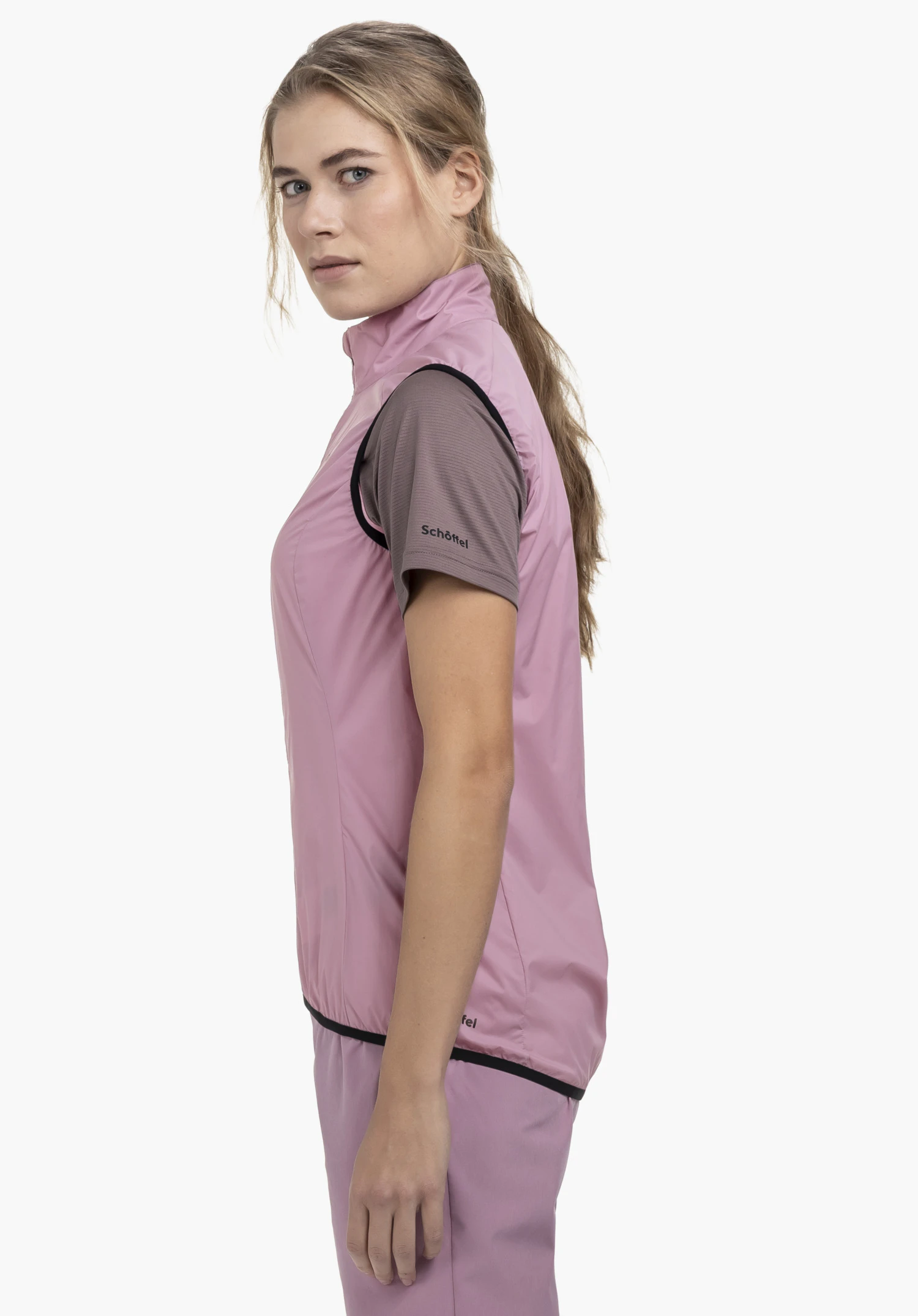 Vest Style Cannobio WMS in soft pink. The model stands in profile against a neutral background, showcasing the vest layered over a shirt with a visible Schöffel logo on the sleeve and a subtle Schöffel logo on the bottom hem.