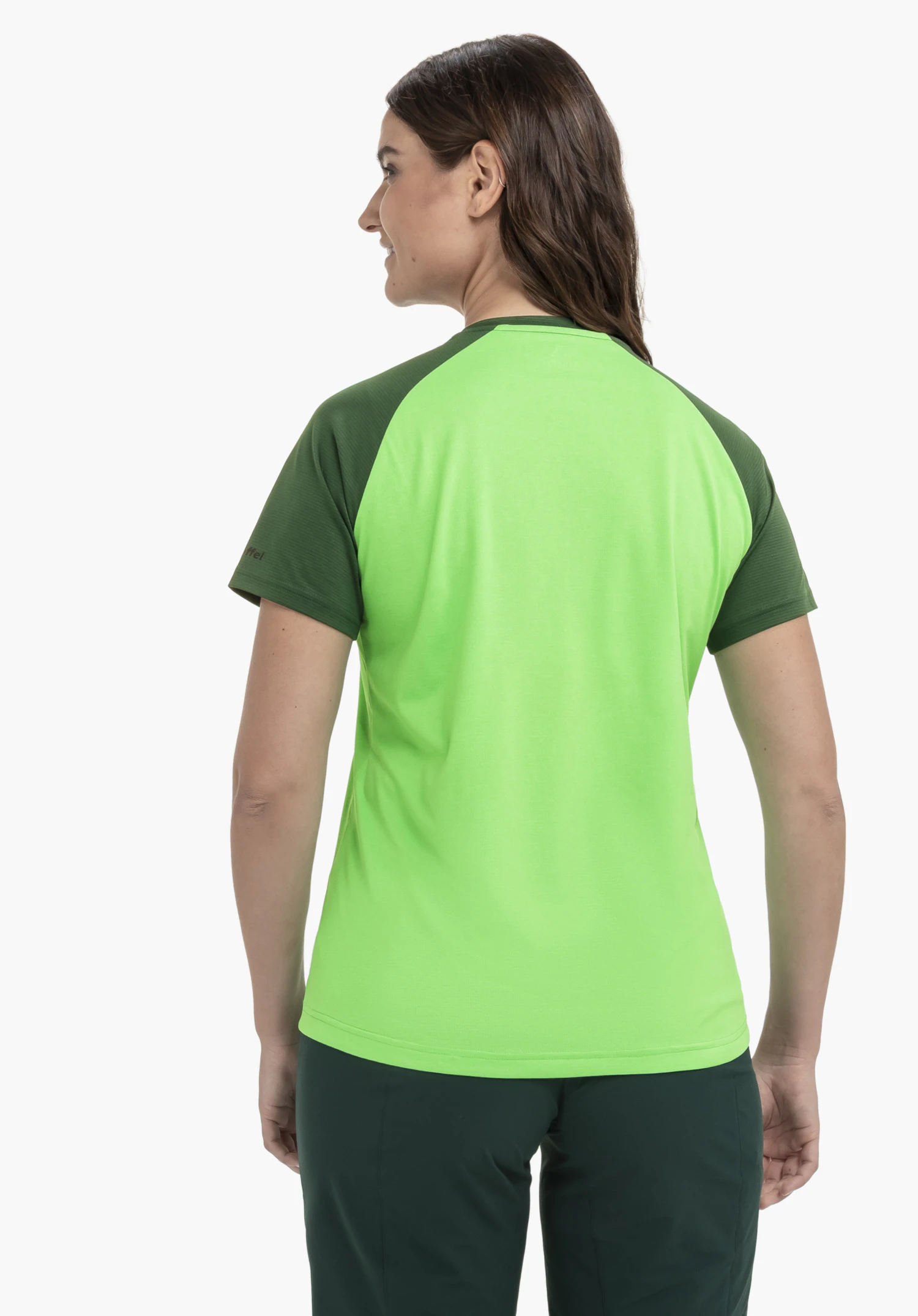 CIRC Shirt Style Wetluga WMS in Grün. Das Model ist in einer Rückenansicht vor einem neutralen Hintergrund zu sehen. Das Shirt besticht durch die kontrastreiche Farbkombination und ein dezent platziertes Schöffel-Logo am Ärmel.