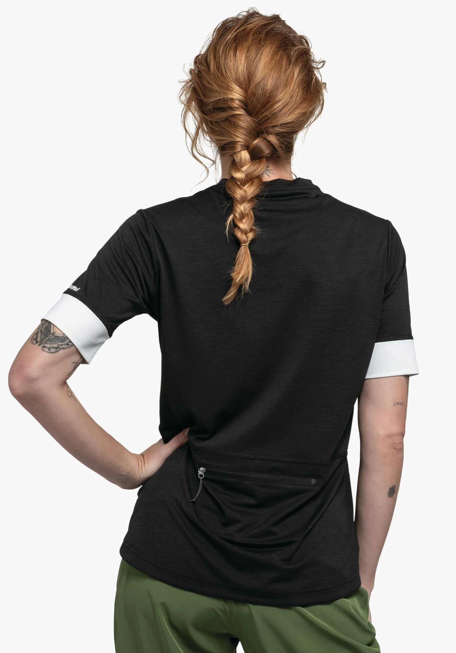 CIRC Shirt Style Pinega WMS zeigt sich hier in der Rückenansicht vor neutralem Hintergrund. Das Model trägt das schwarze Shirt mit kontrastierenden Ärmelenden, wobei das dezente Schöffel-Logo am rechten Ärmel platziert ist.