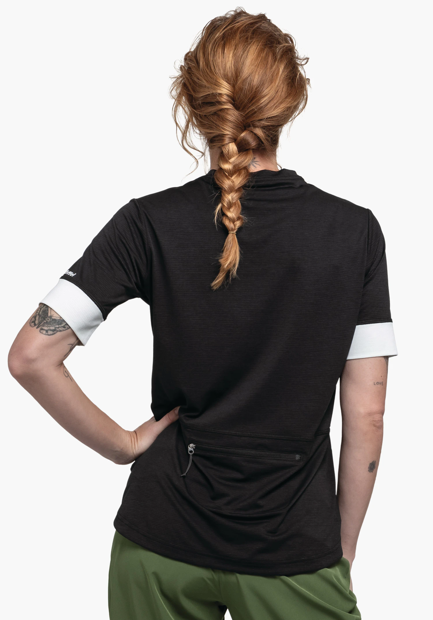 CIRC Shirt Style Pinega WMS est présenté ici vu de dos sur un fond neutre. Le mannequin porte le t-shirt noir avec des bas de manches contrastés, le logo Schöffel étant discrètement placé sur la manche droite.