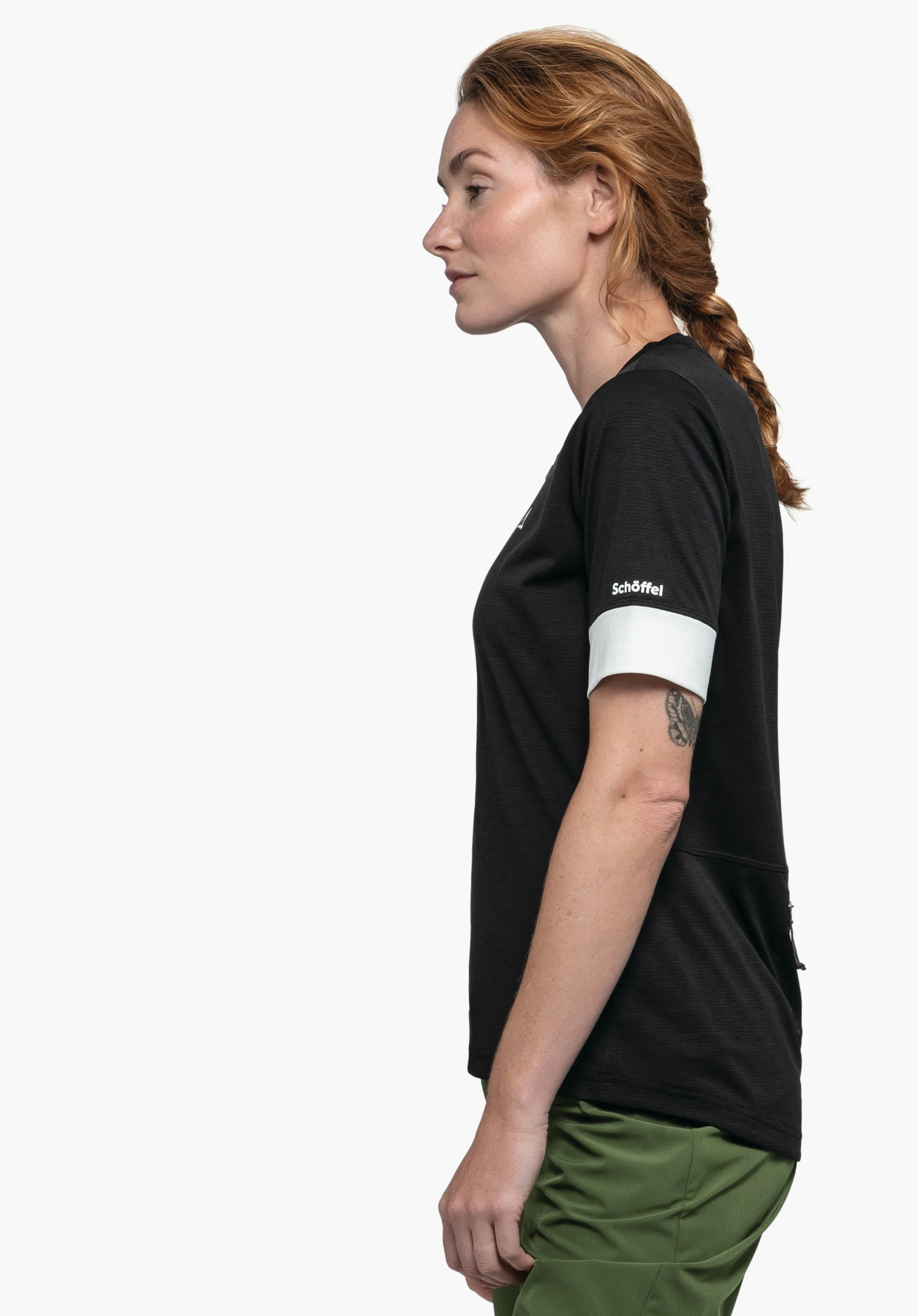 CIRC Shirt Style Pinega WMS: Das Modell steht seitlich vor einem neutralen Hintergrund und präsentiert das Shirt in Schwarz. Ein dezentes Schöffel-Logo ist am Ärmel zu sehen.