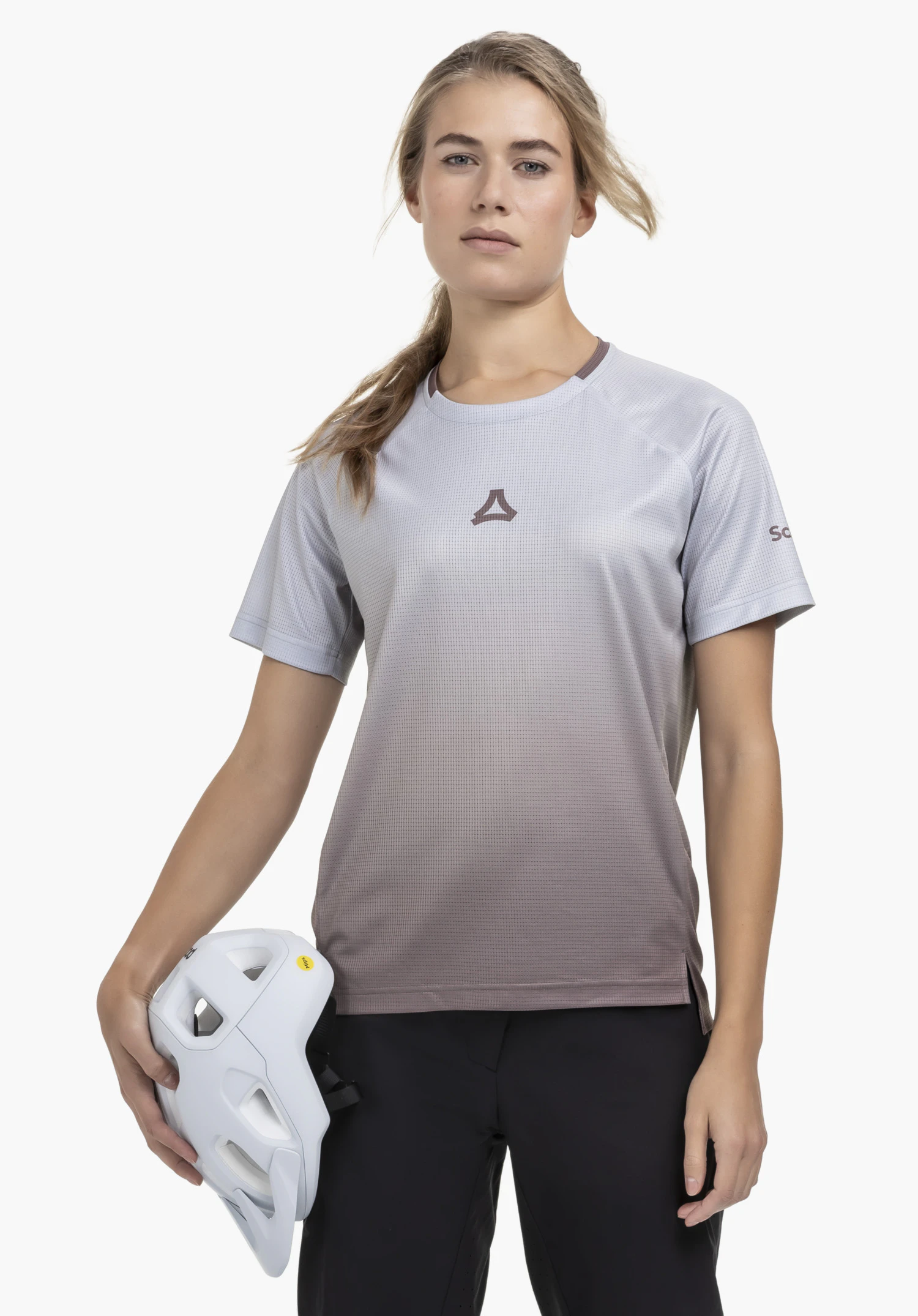 Shirt Style Koitere WMN präsentiert sich an einer Model-Figur in der Frontalansicht vor einem neutralen Hintergrund. Das Shirt in einem sanften Farbverlauf hin zu einem warmen Braunton trägt das dezente Schöffel-Logo auf der Brust und am Ärmel.