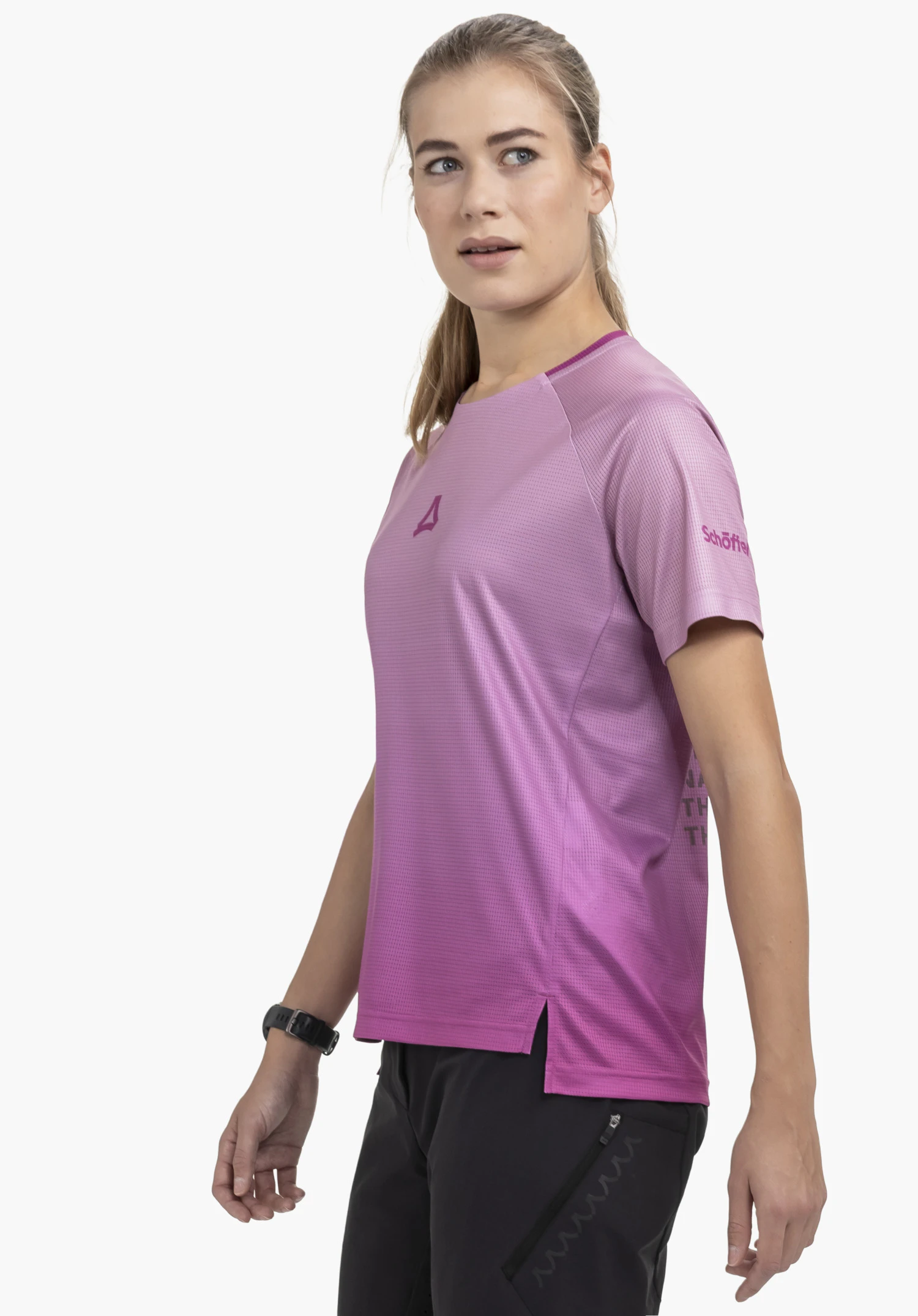 Shirt Style Koitere WMN in pink. A model stands in a side-profile pose against a neutral background, showcasing the shirt with the clearly visible Schöffel logo on the sleeve. The image highlights the functional fit and the modern colour.