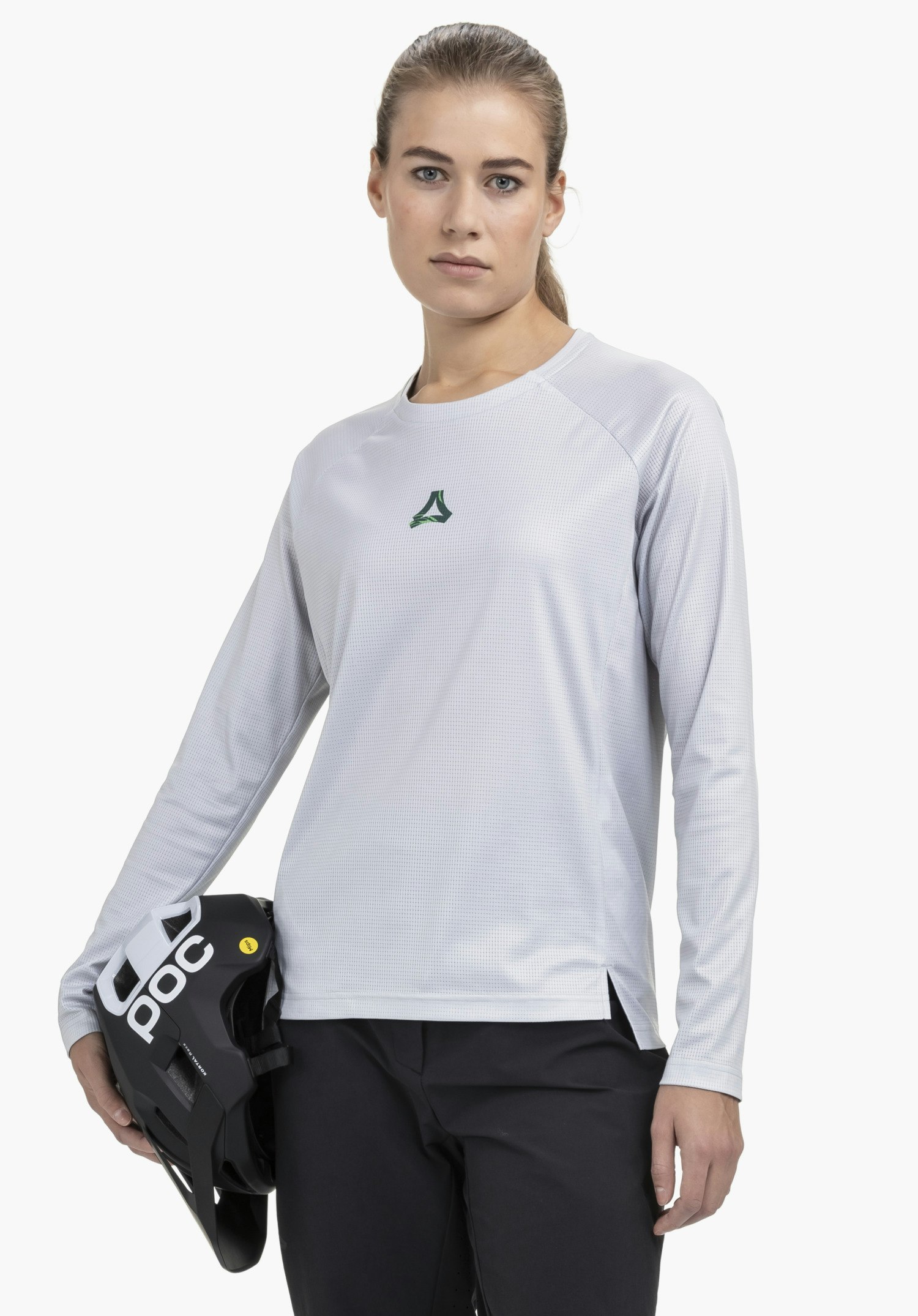 Longsleeve Style Koitere WMN in grey, shown on a model against a neutral background. The model faces the camera directly while holding a helmet. The subtle Schöffel logo is clearly visible on the chest.